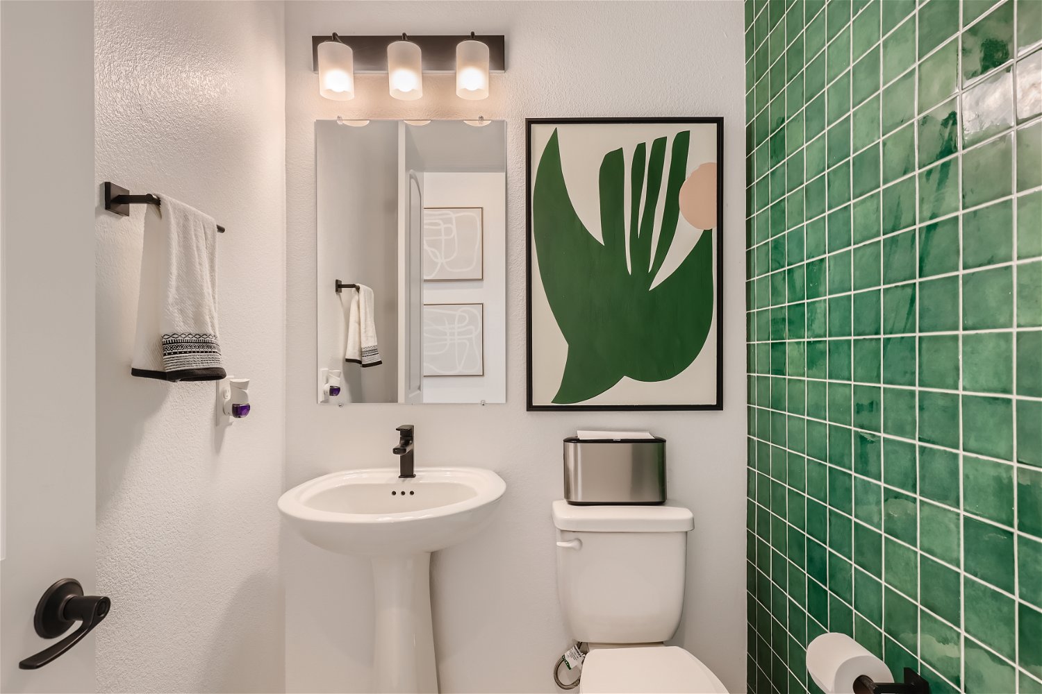A bathroom with a sink toilet and a mirror.