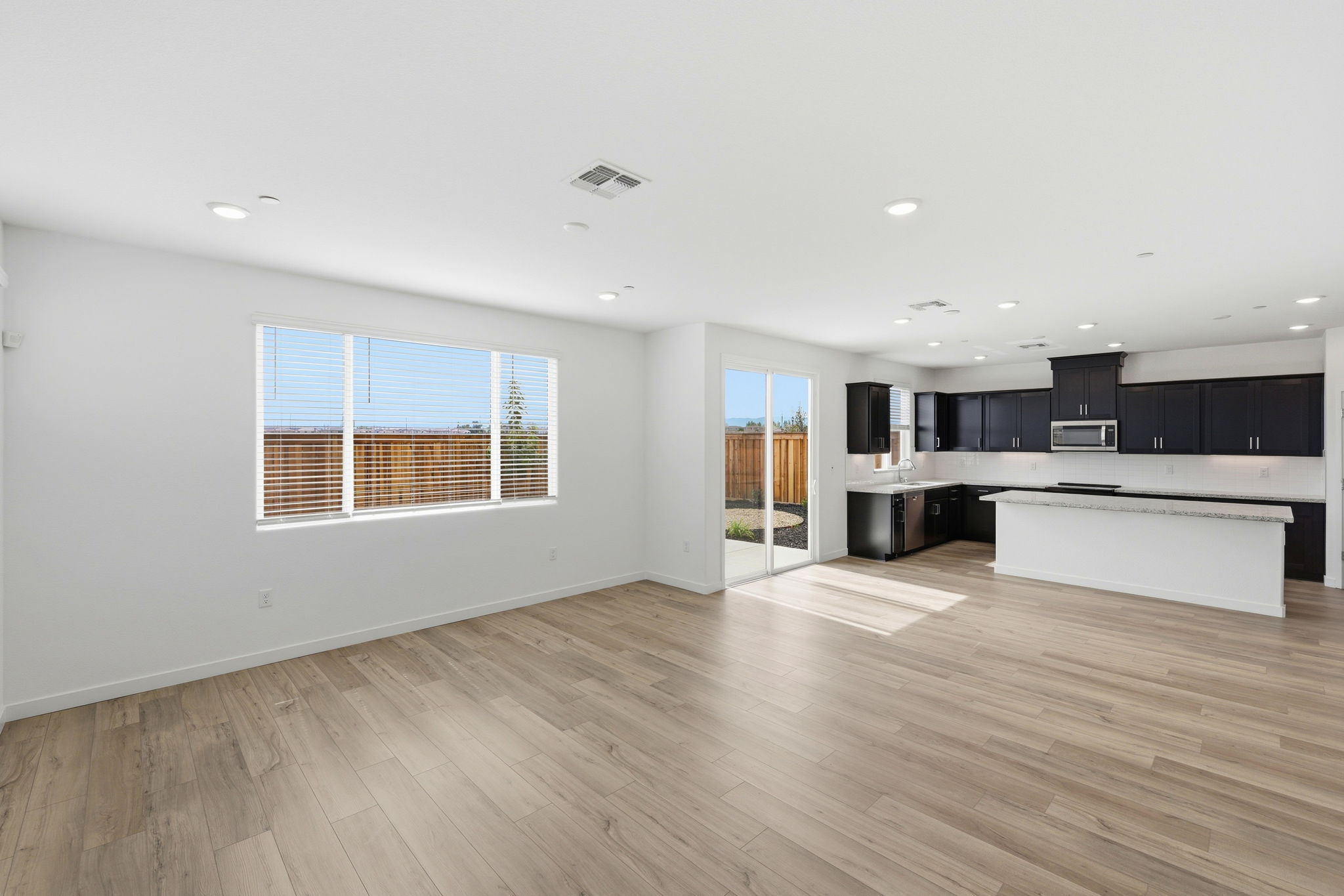 A large empty room with a wood floor and a large window.