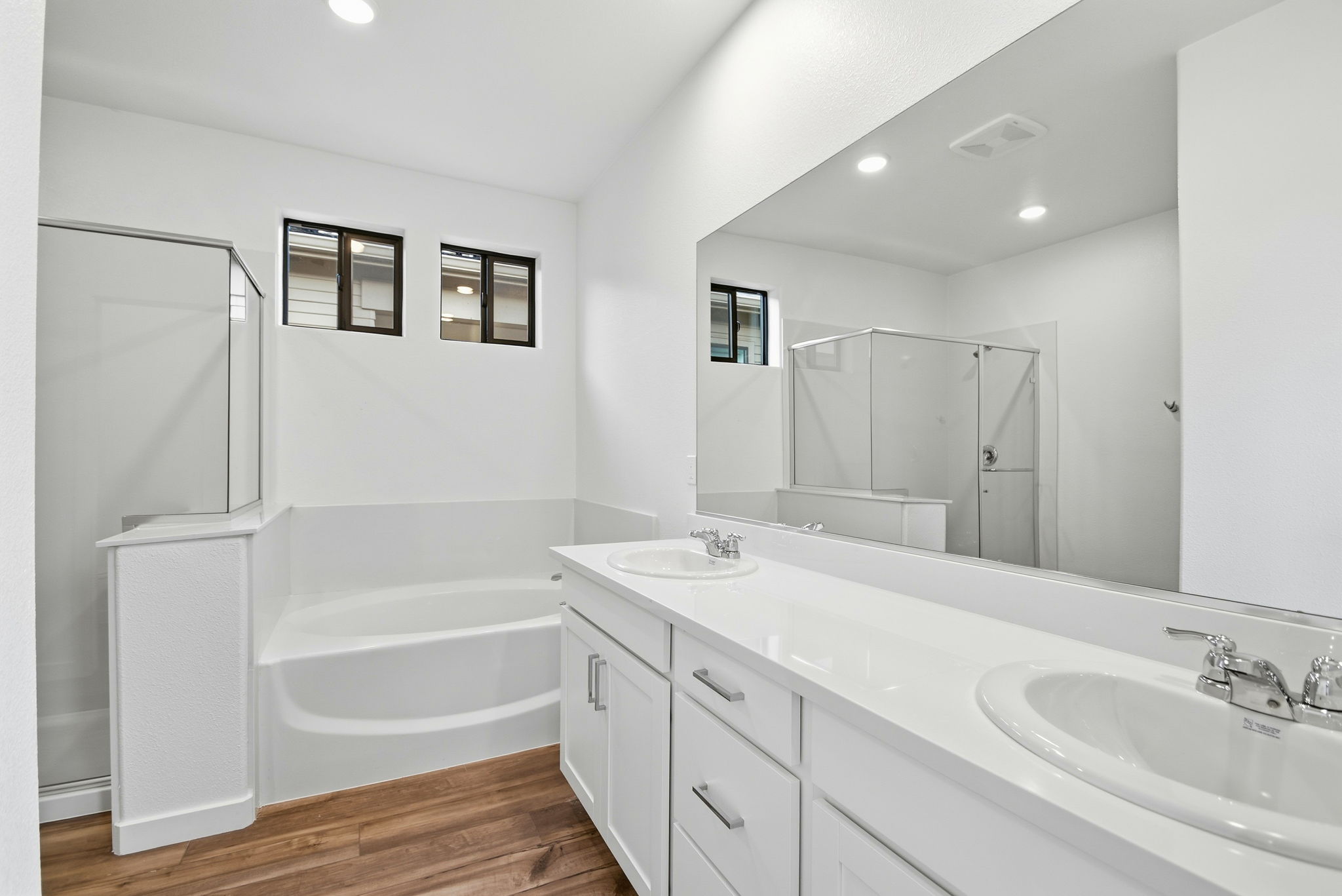 A bathroom with a tub sink and a mirror.