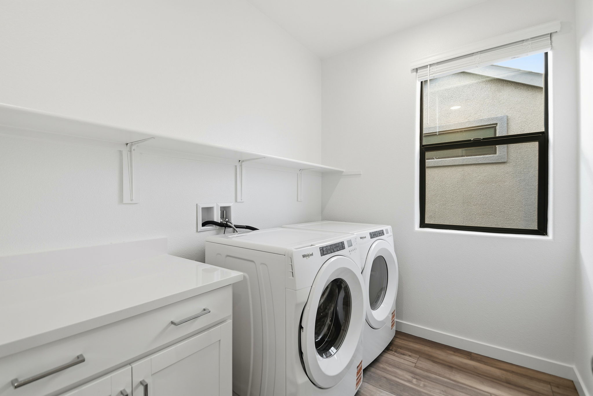 A white room with a washing machine and a window.
