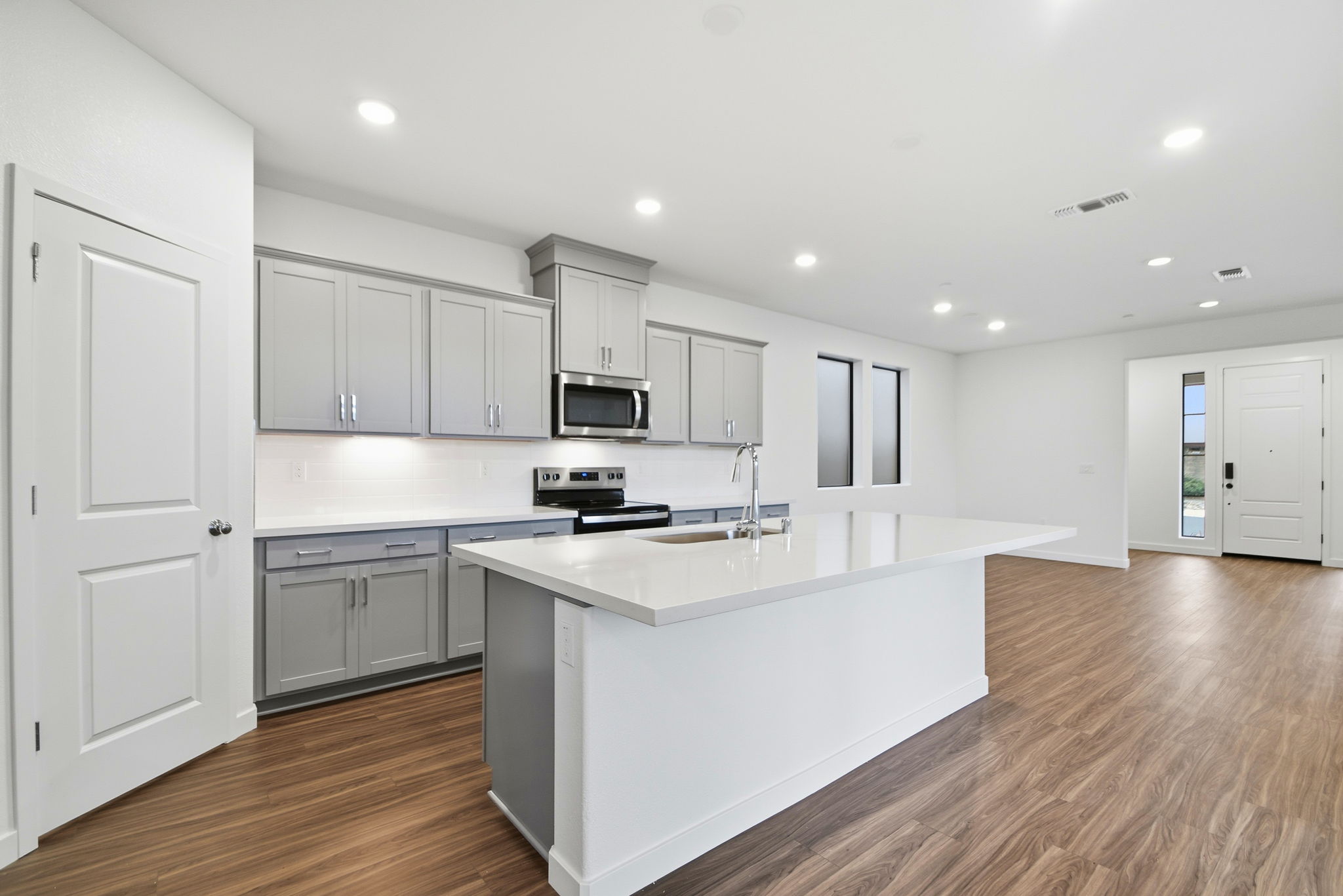 A kitchen with white cabinets.