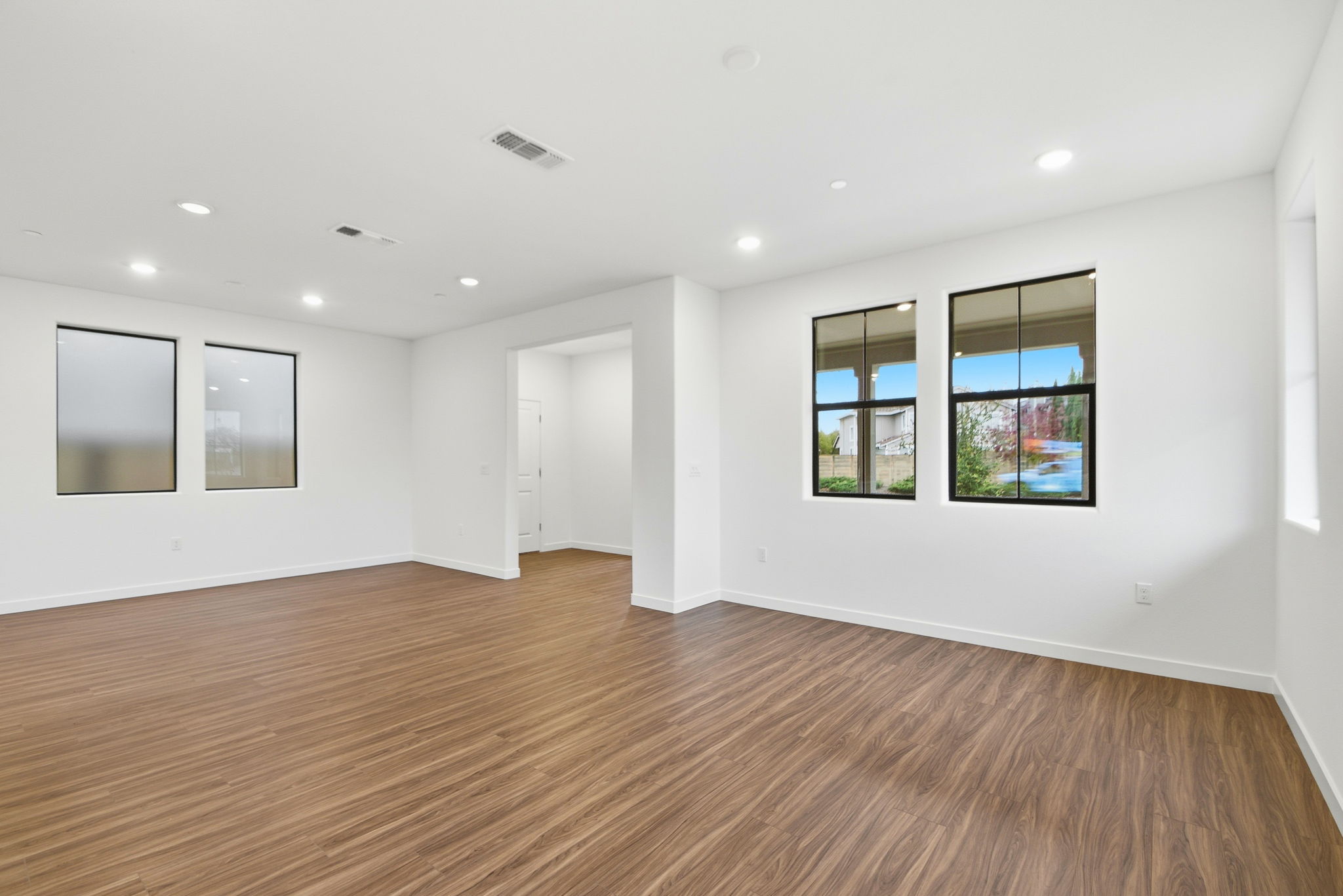A room with a wood floor and a wood floor with a window.