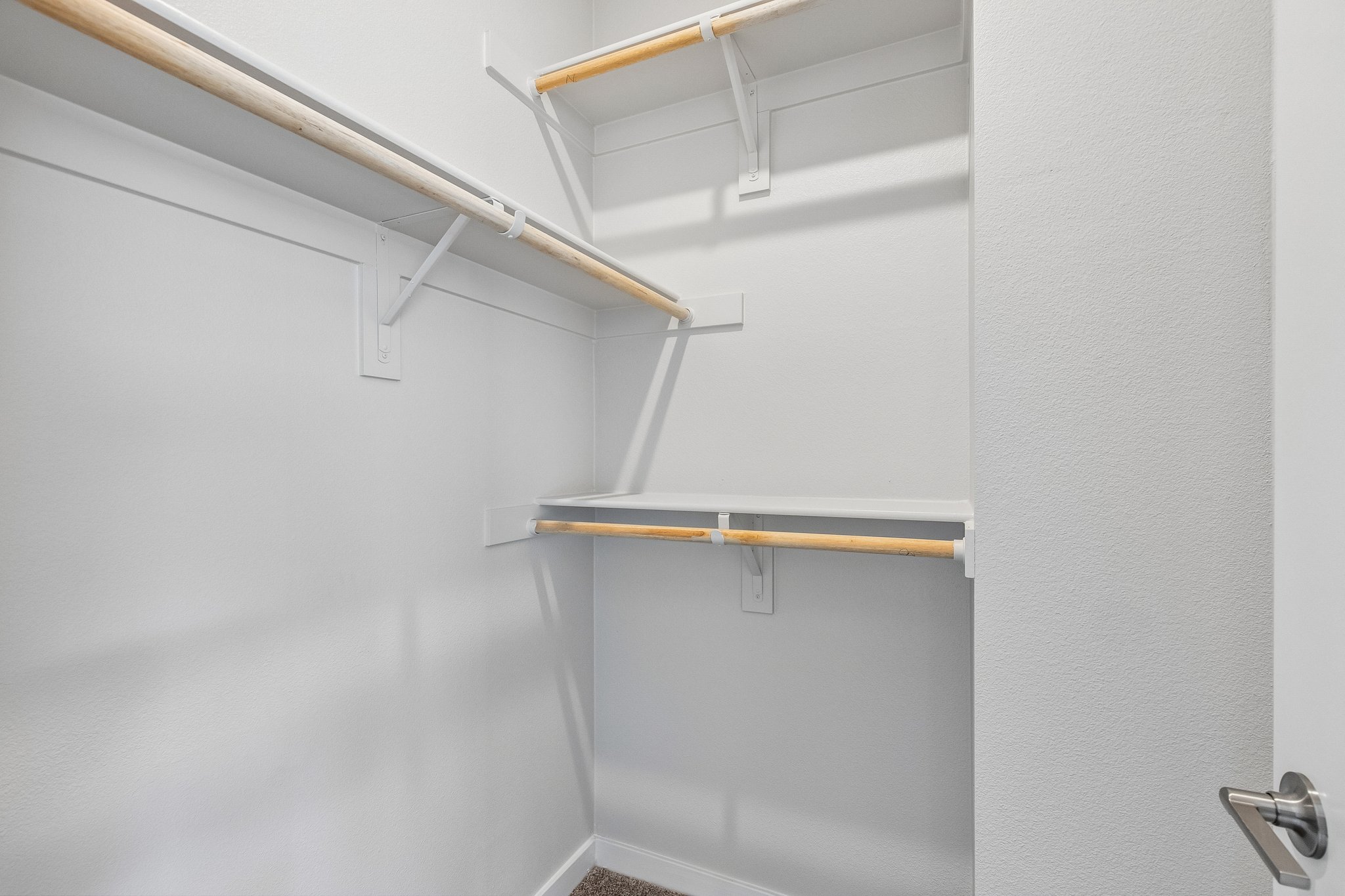 A white wall with a metal bar.