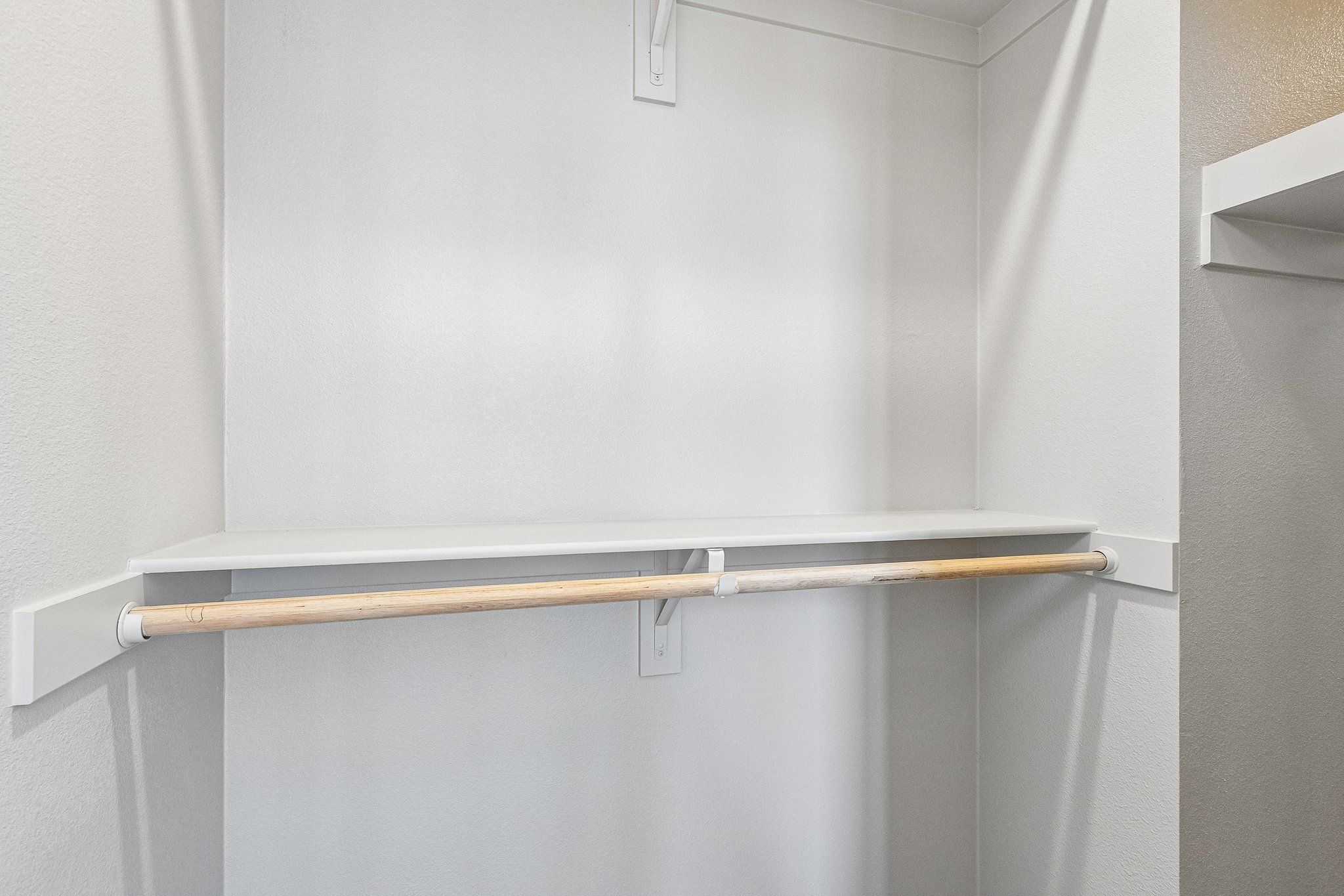 A white wall with a metal bar.