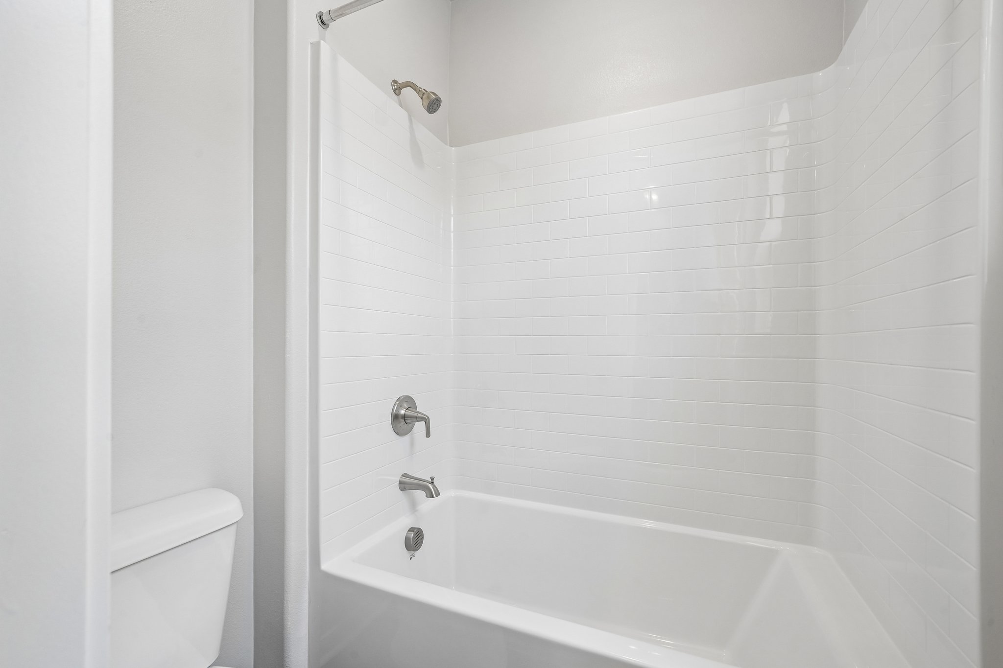 A bathroom with a bathtub and toilet.
