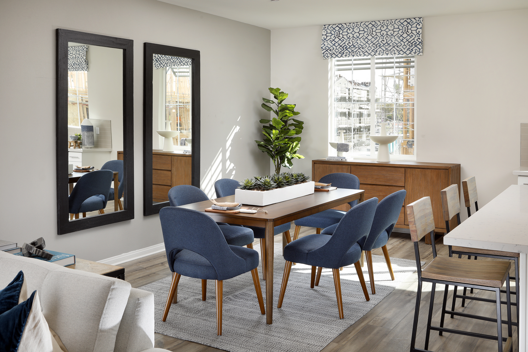 A room with a table chairs and a plant.