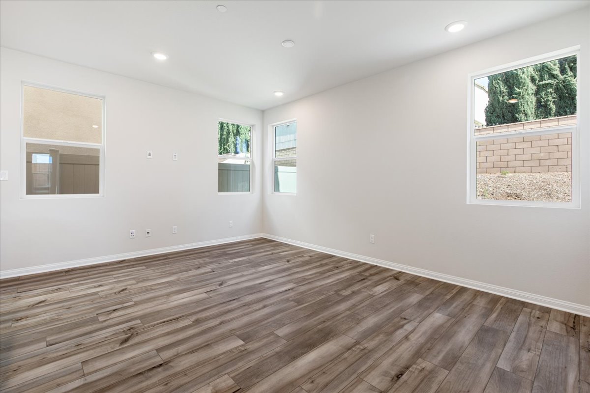 A room with windows and wood floor.