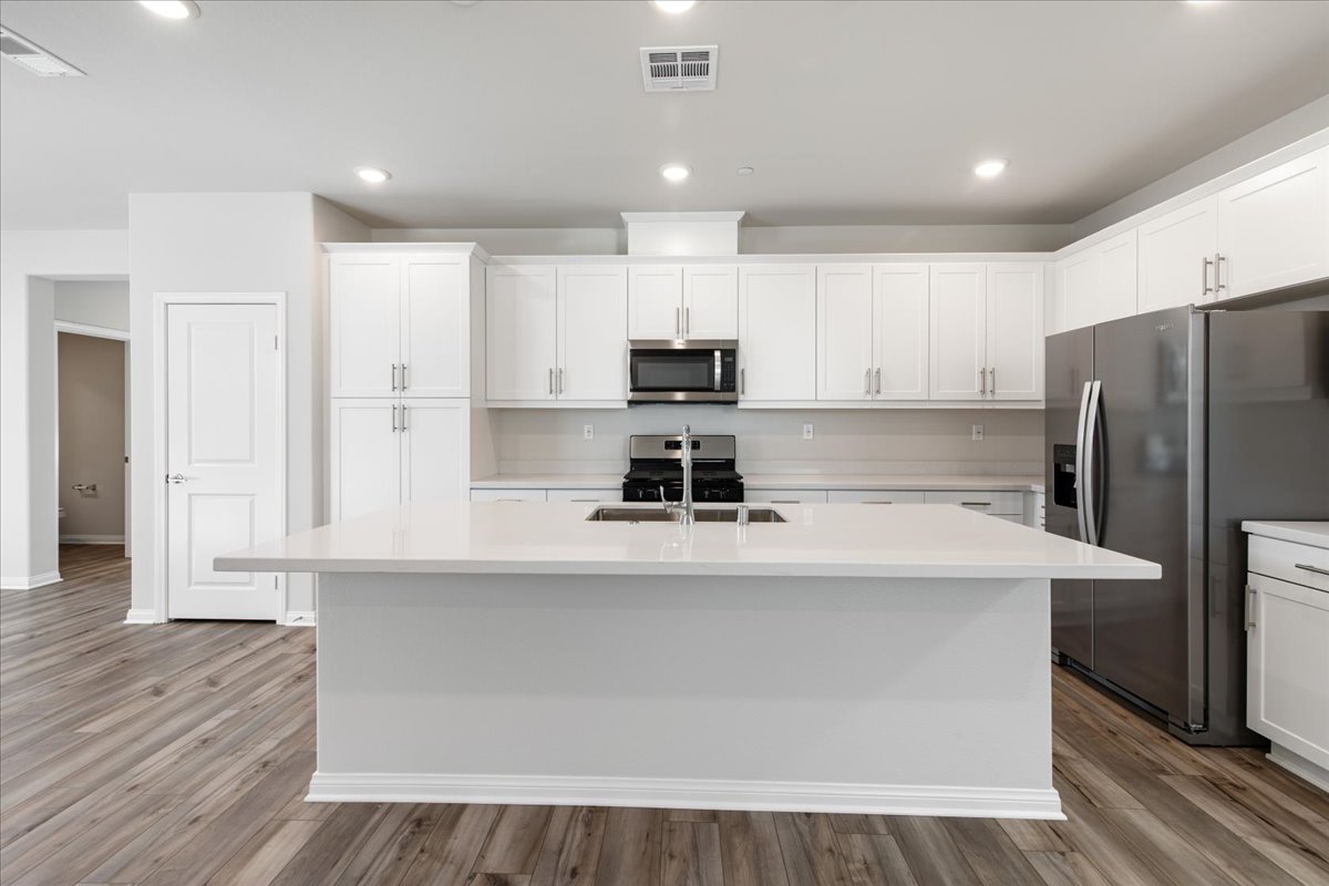 A kitchen with white cabinets.