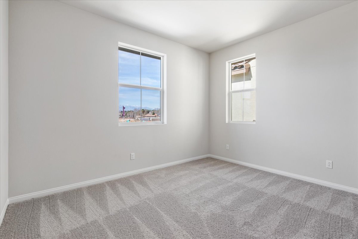A room with a window and a rug.