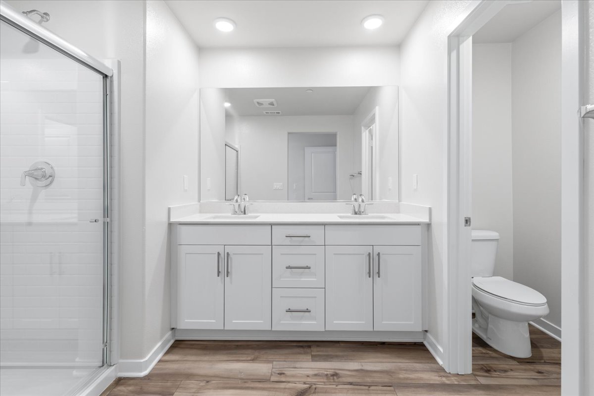 A bathroom with white cabinets.
