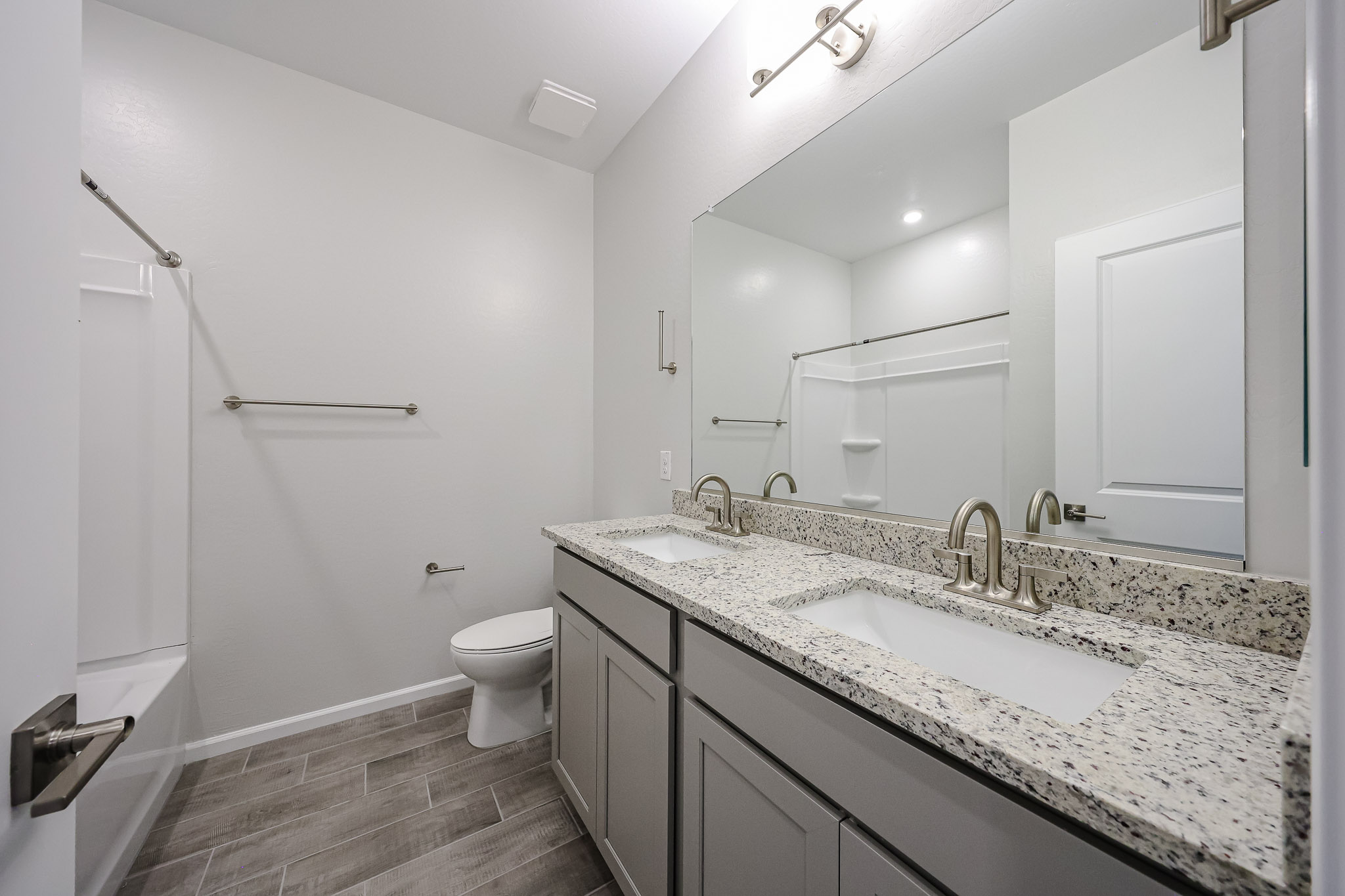 A bathroom with a large mirror.