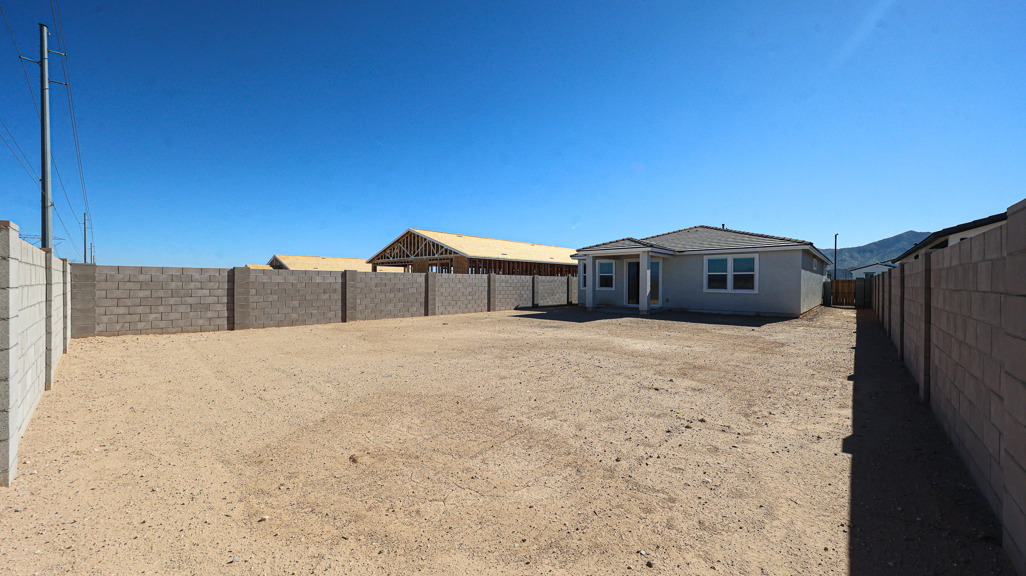 A dirt road with buildings on the side.
