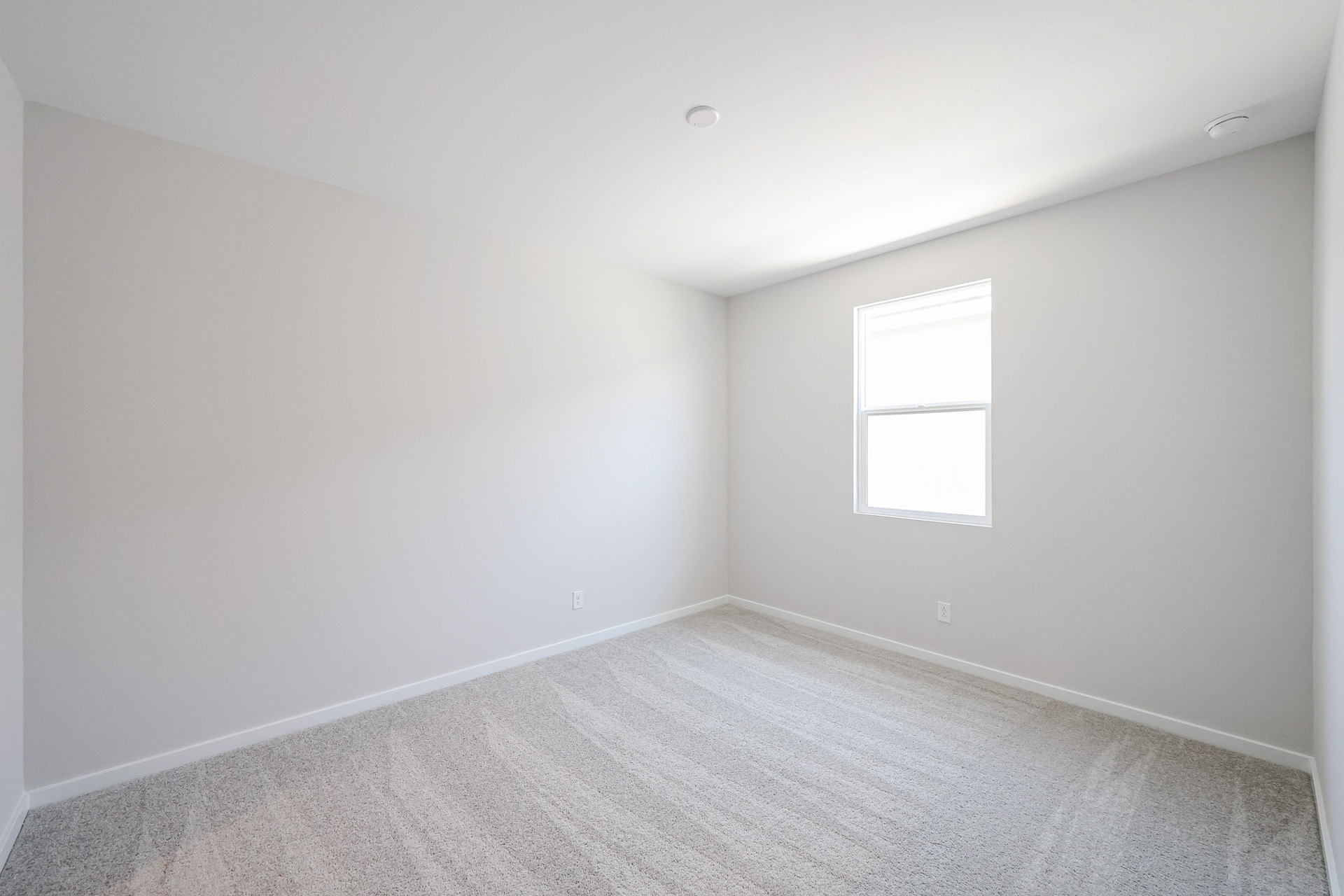 A room with a white wall and a window.