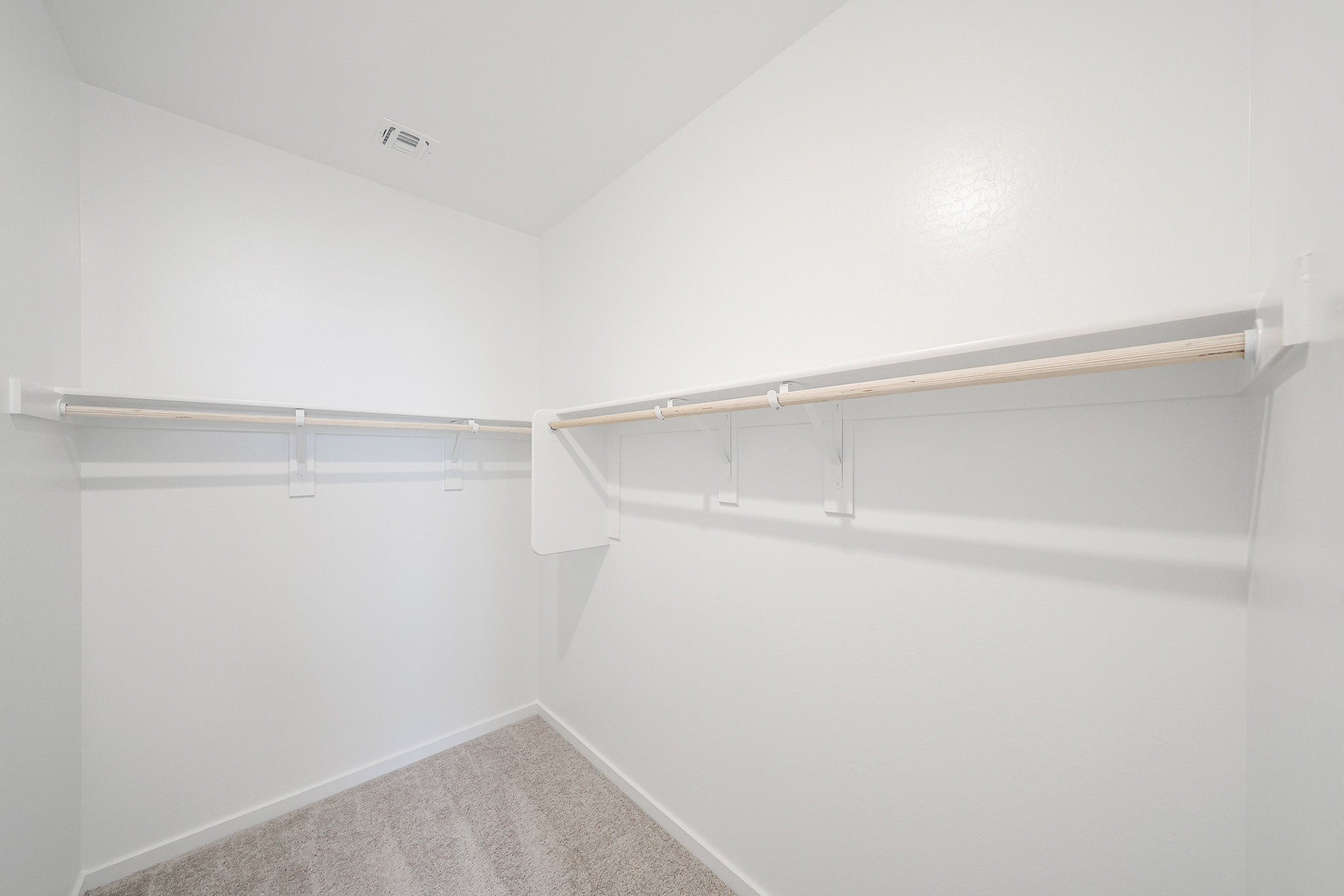A white wall with a metal bar.