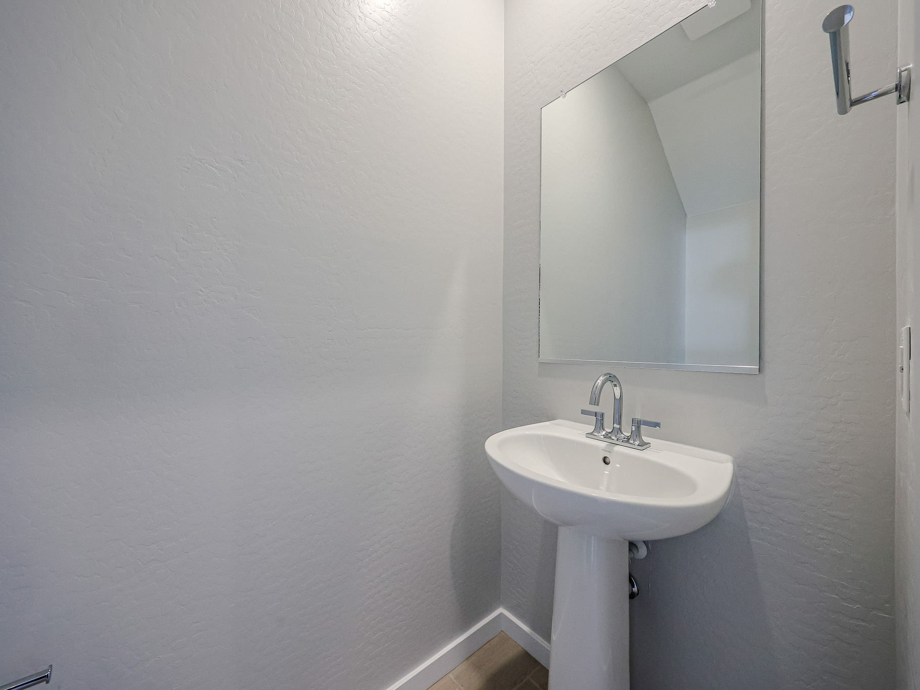 A bathroom with a mirror and sink.