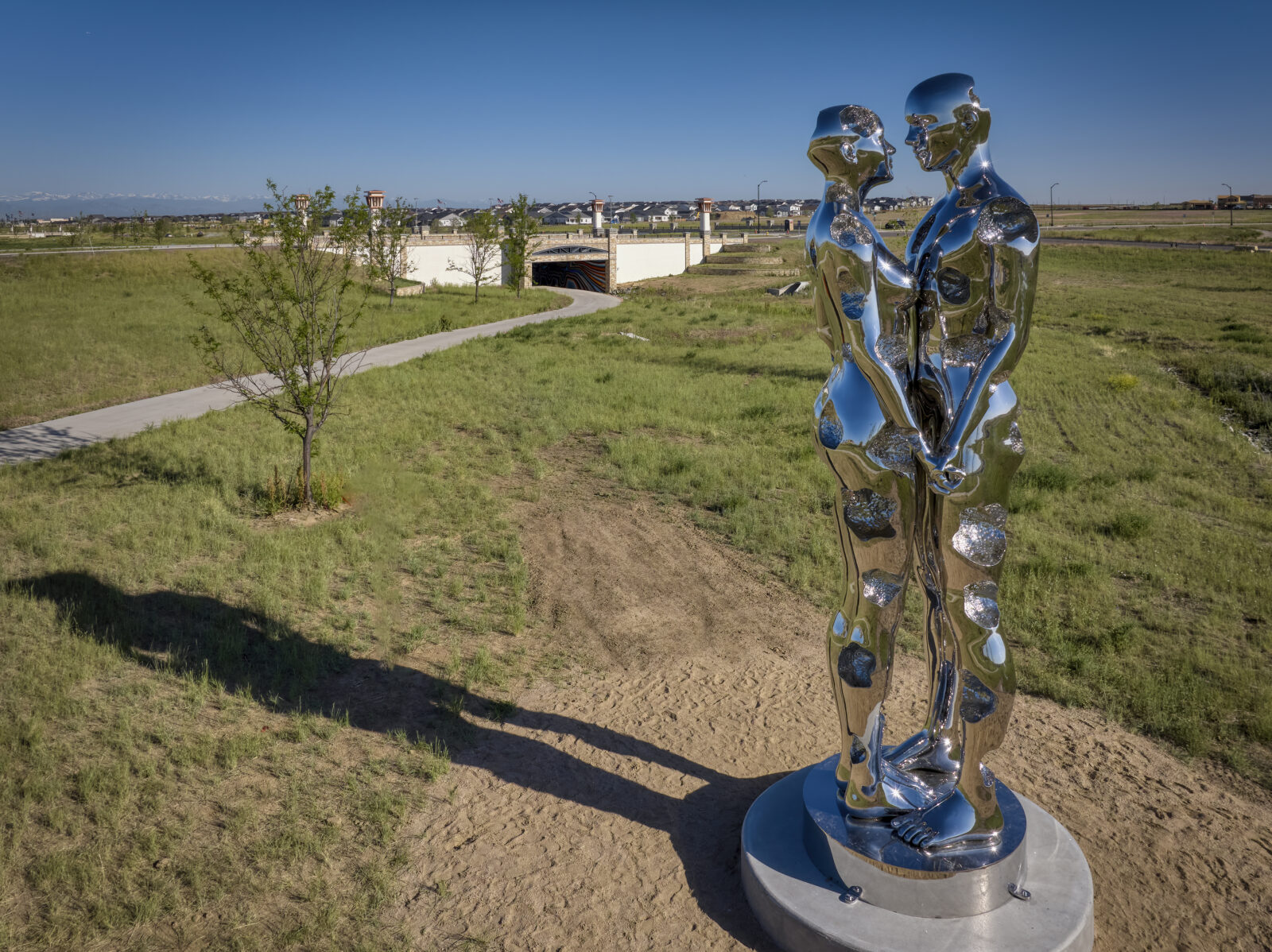 A couple of metal sculptures in a grassy field.