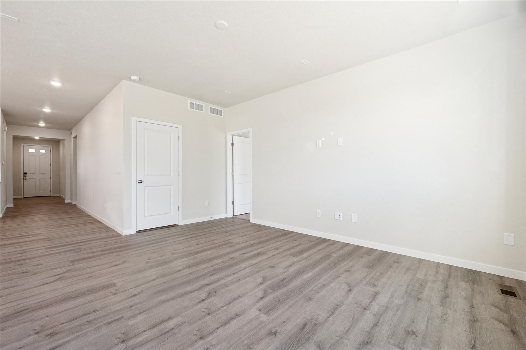 A room with white walls and wood floors.
