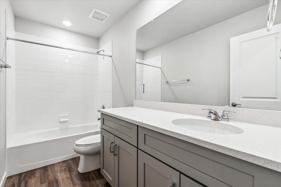 A bathroom with a tub sink and toilet.