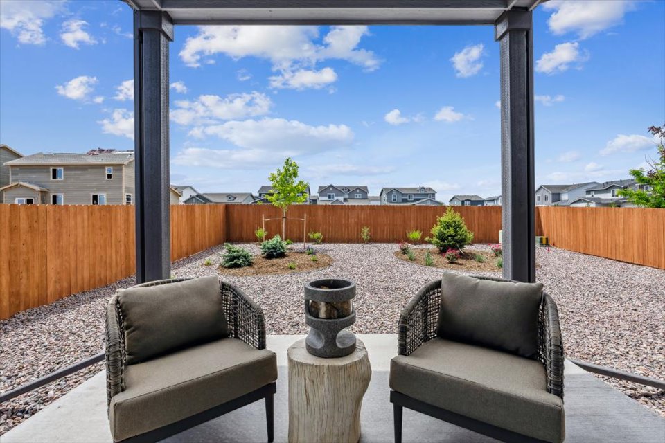 A patio with a wood fence and a patio with a wood railing.