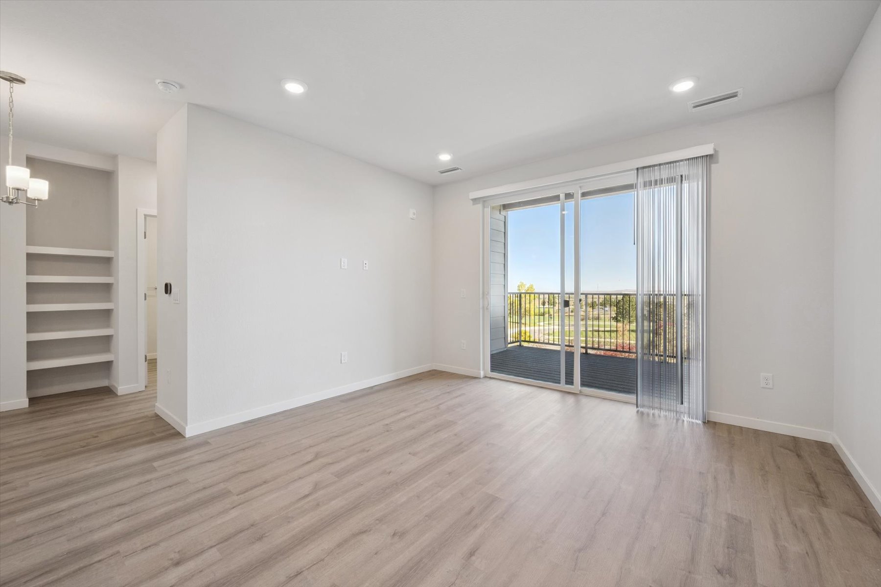 A room with a wood floor and a glass door.