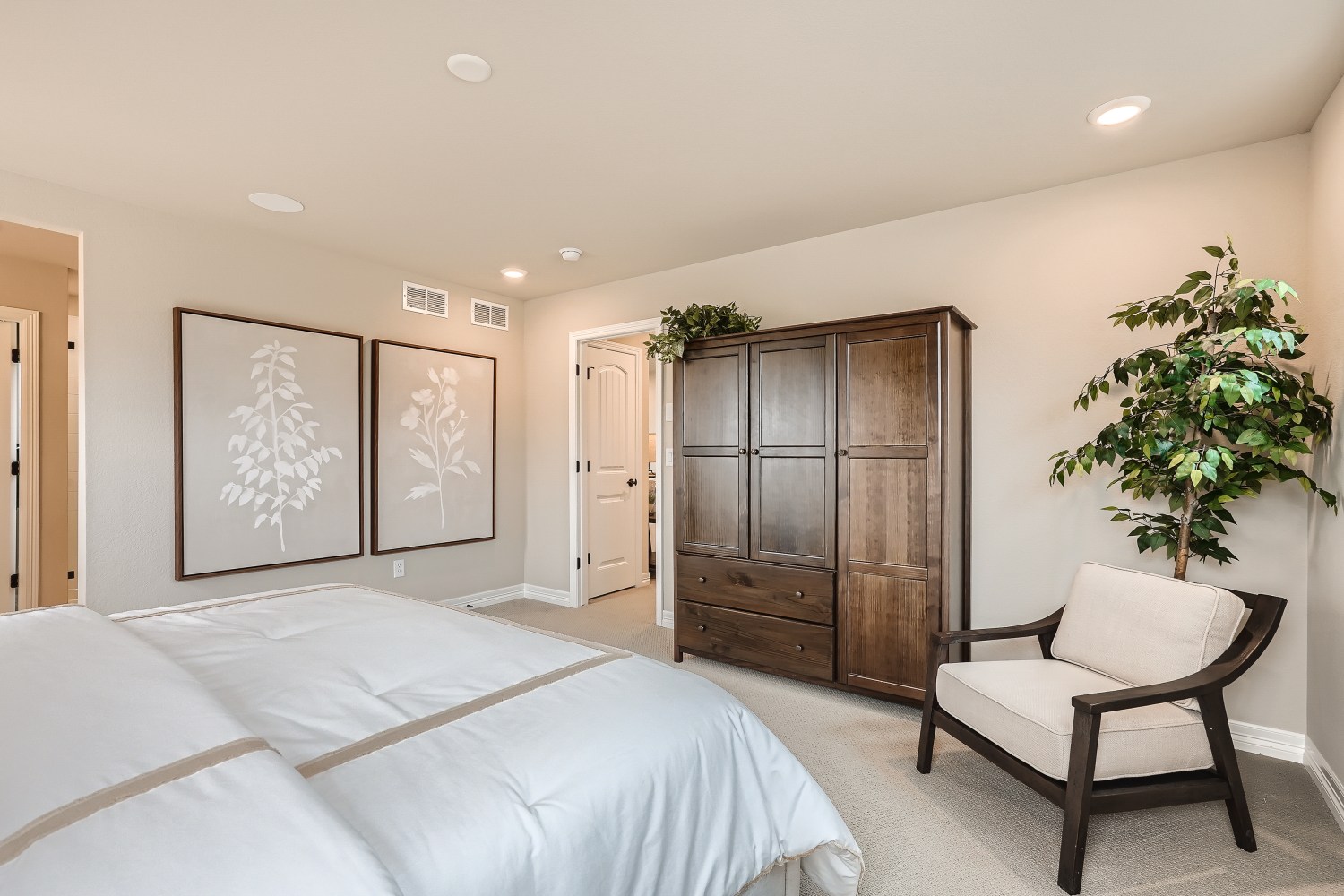 A bedroom with a bed and a chair.