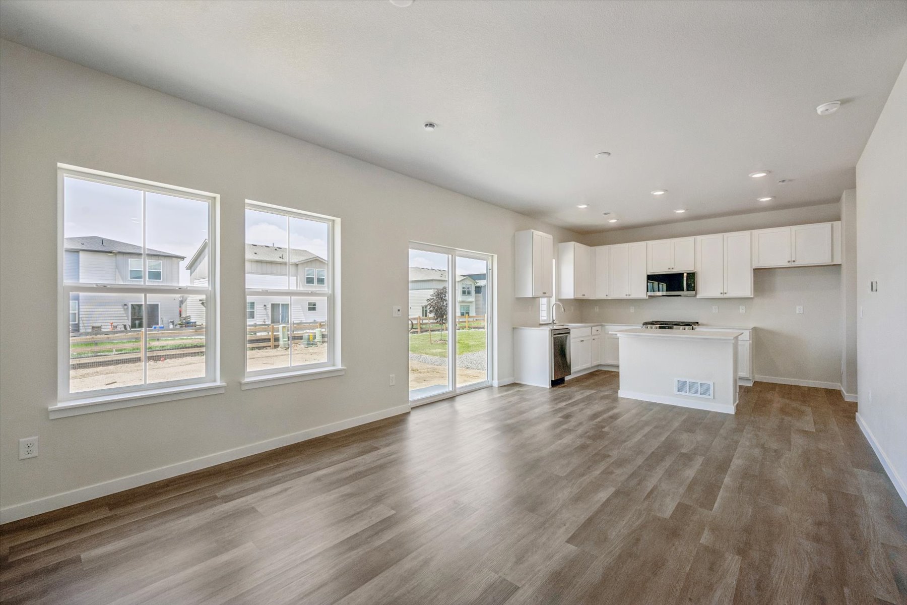A large empty room with white cabinets.