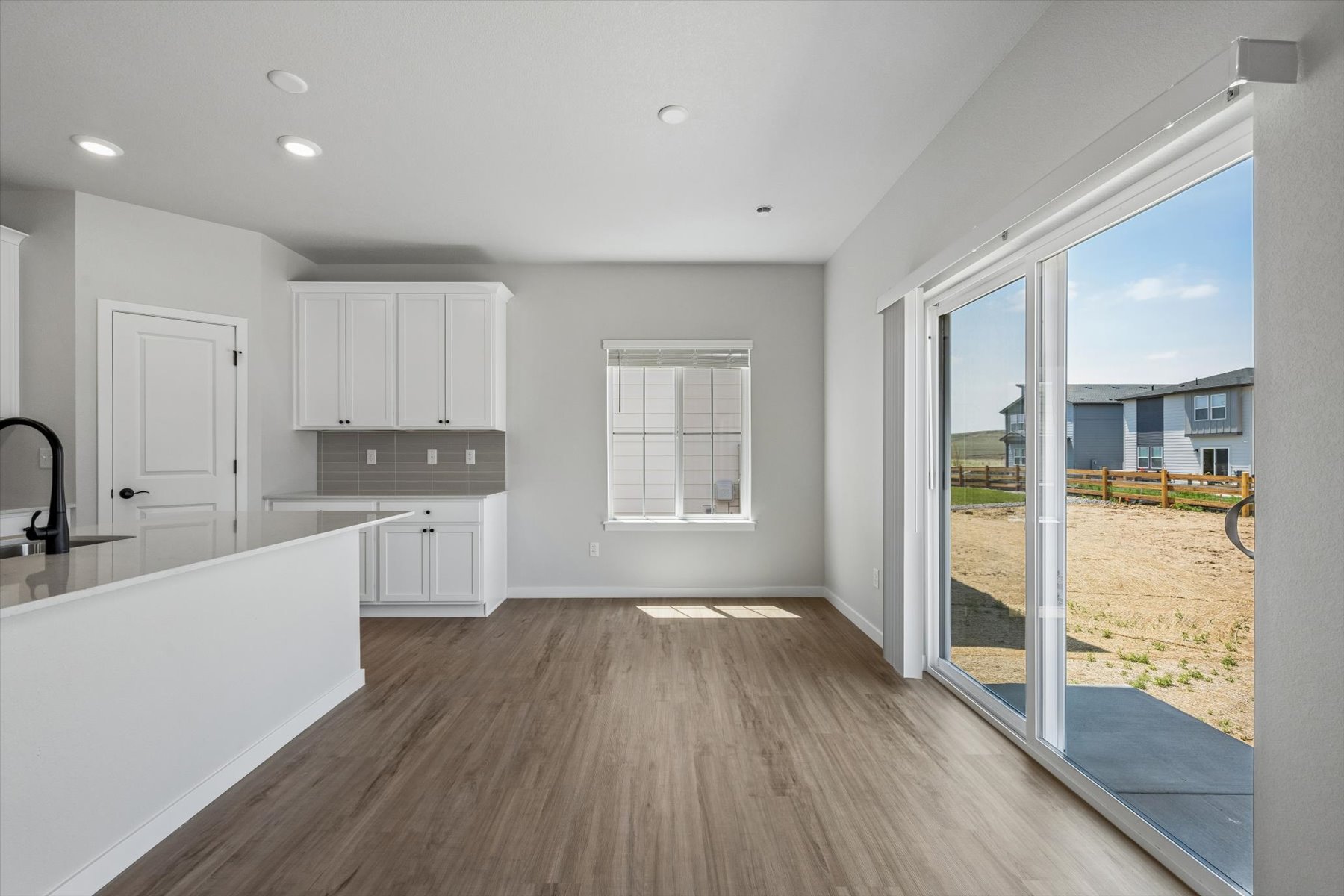 A room with a wood floor and white cabinets.