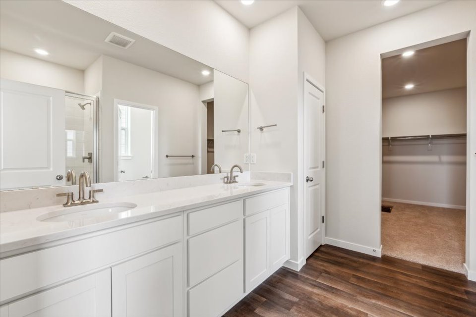 A bathroom with white cabinets.