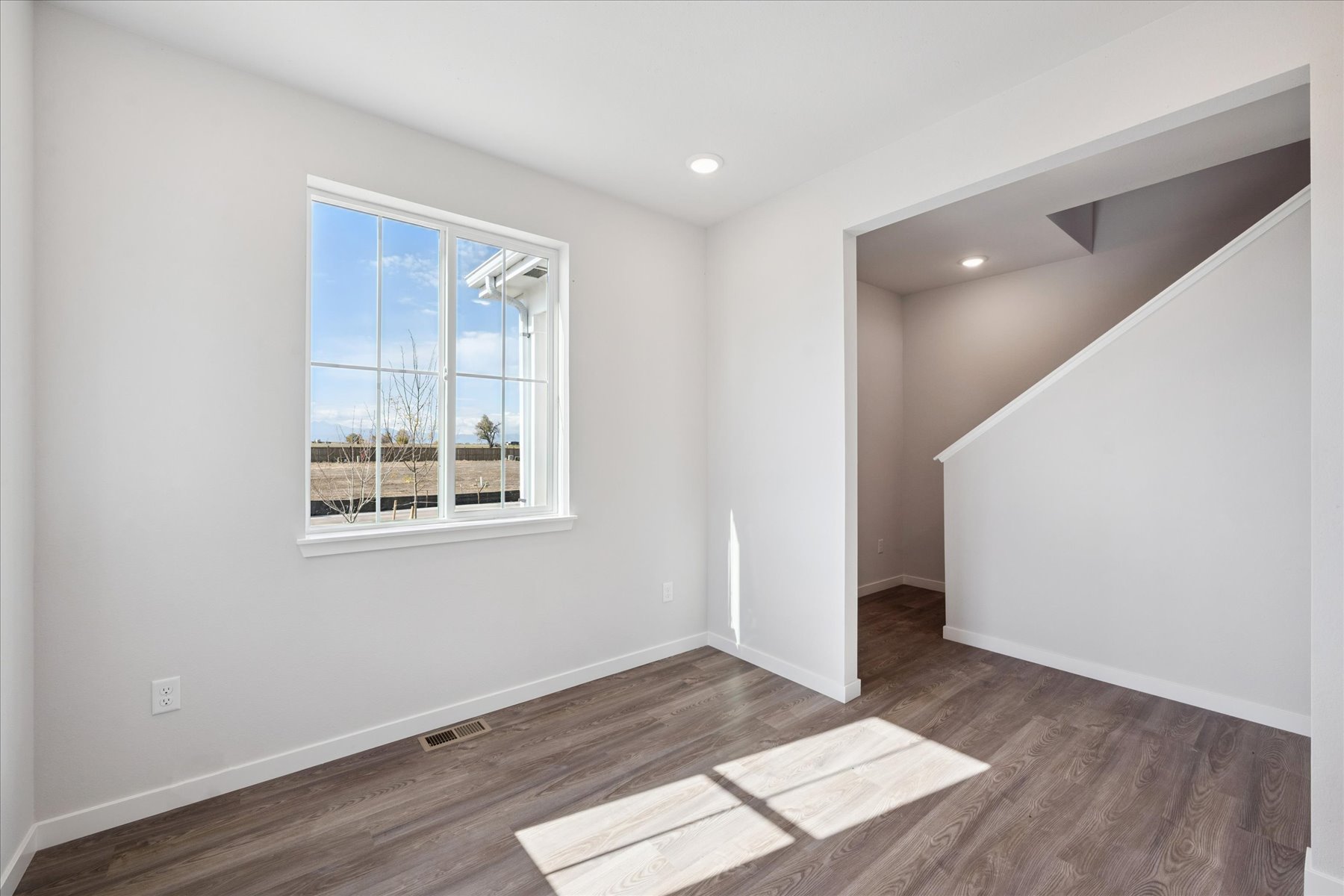 A room with a window and a rug in it.