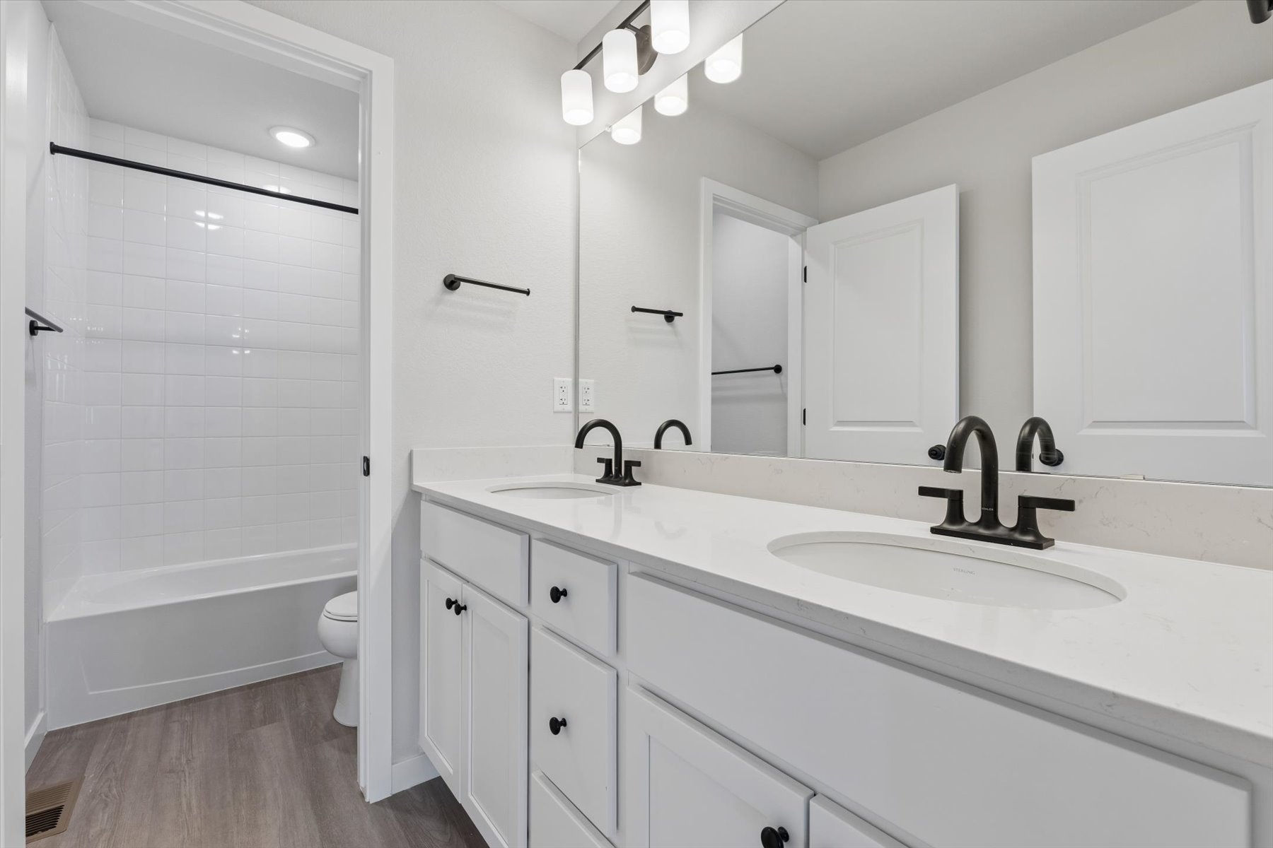 A bathroom with white cabinets.