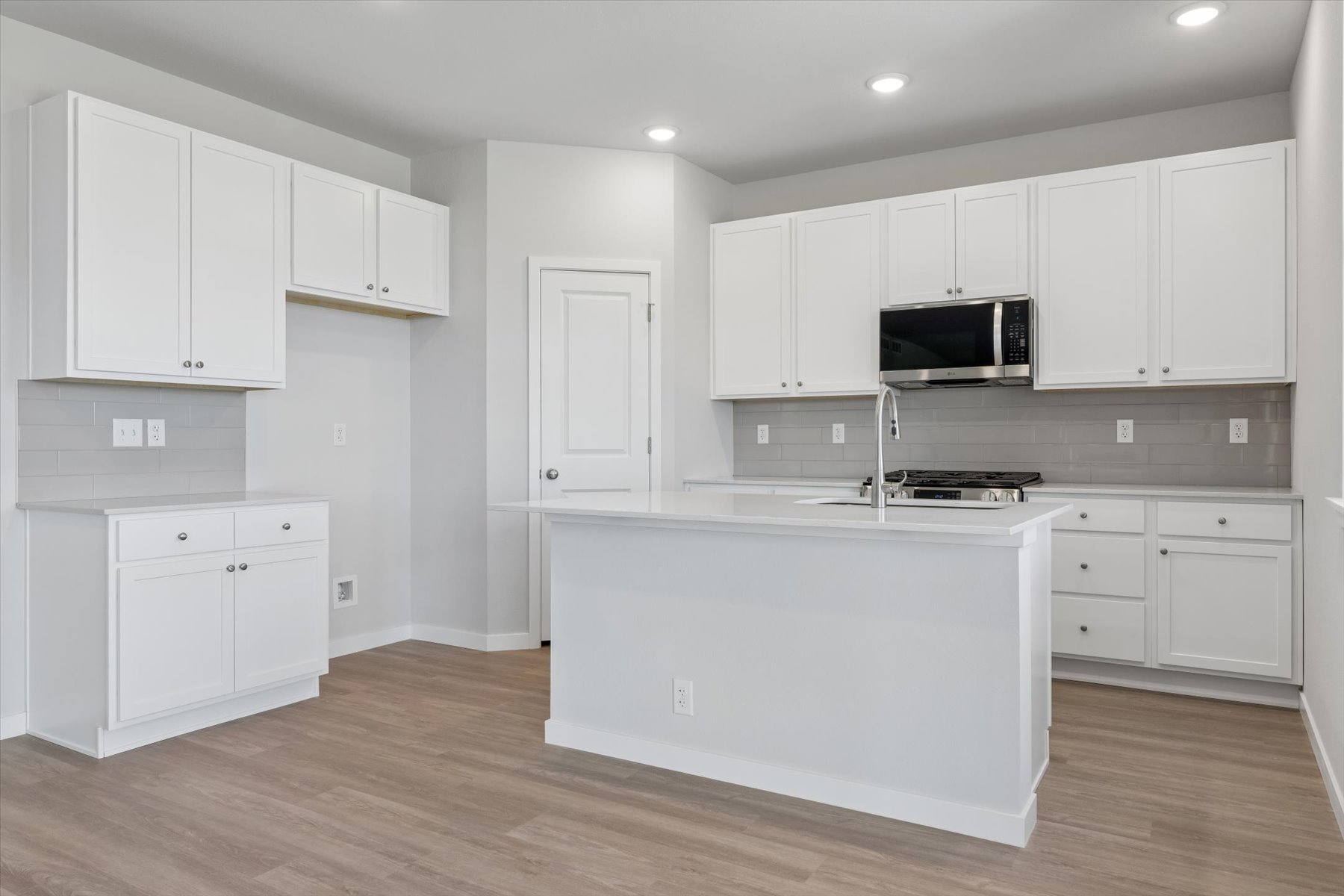 A kitchen with white cabinets.