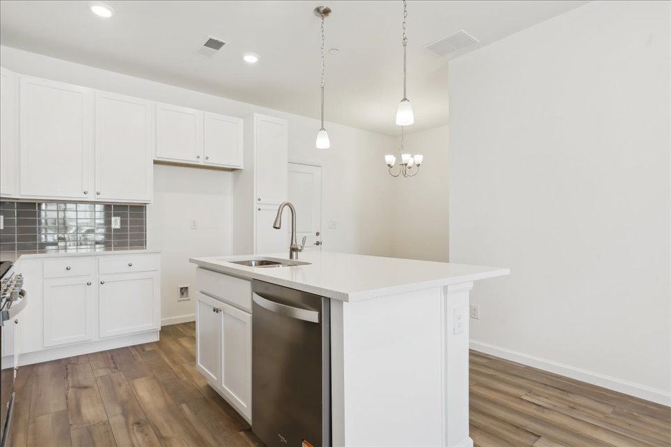 A kitchen with white cabinets.