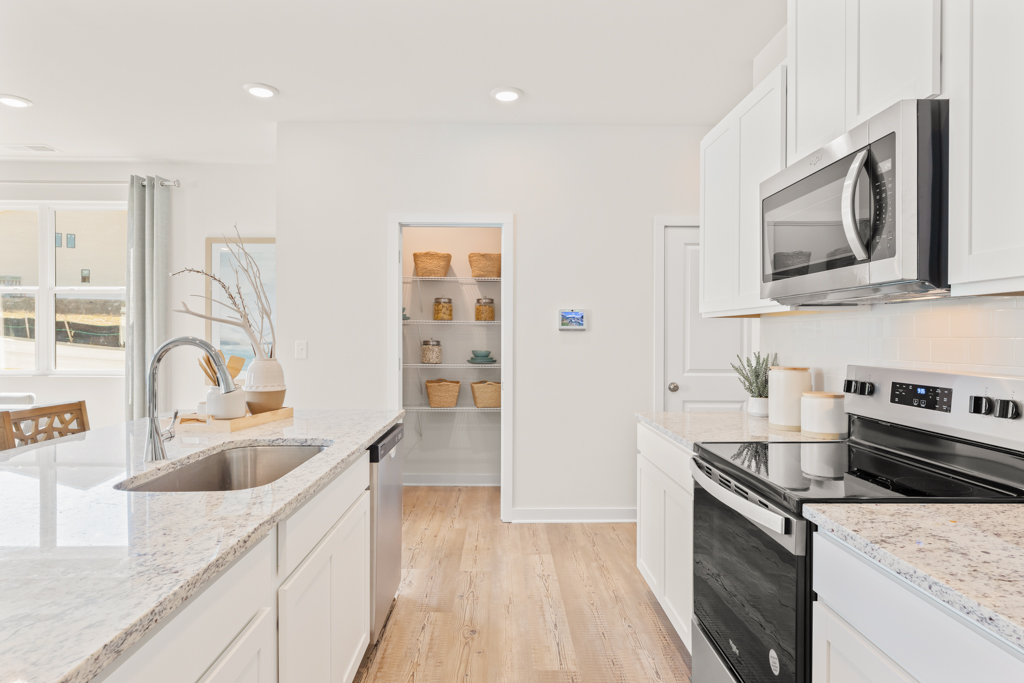 A kitchen with white cabinets.