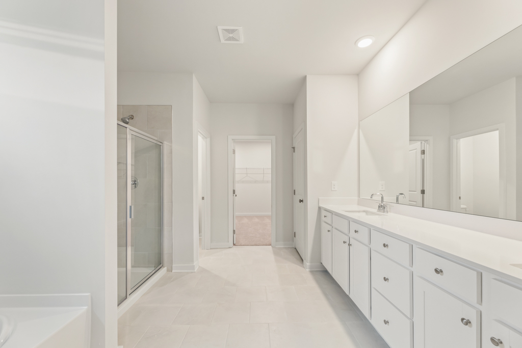 A bathroom with white cabinets.