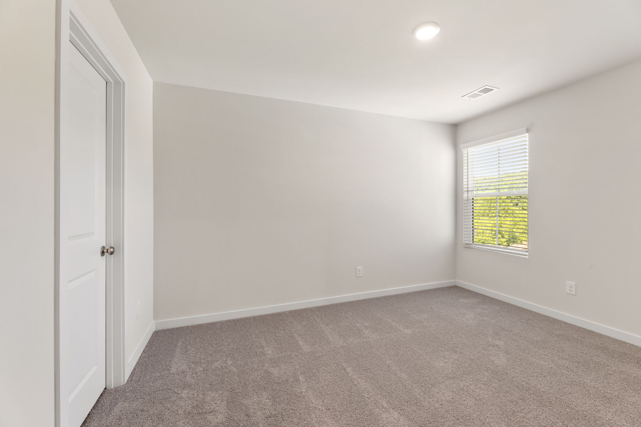 A room with a carpet and a window.
