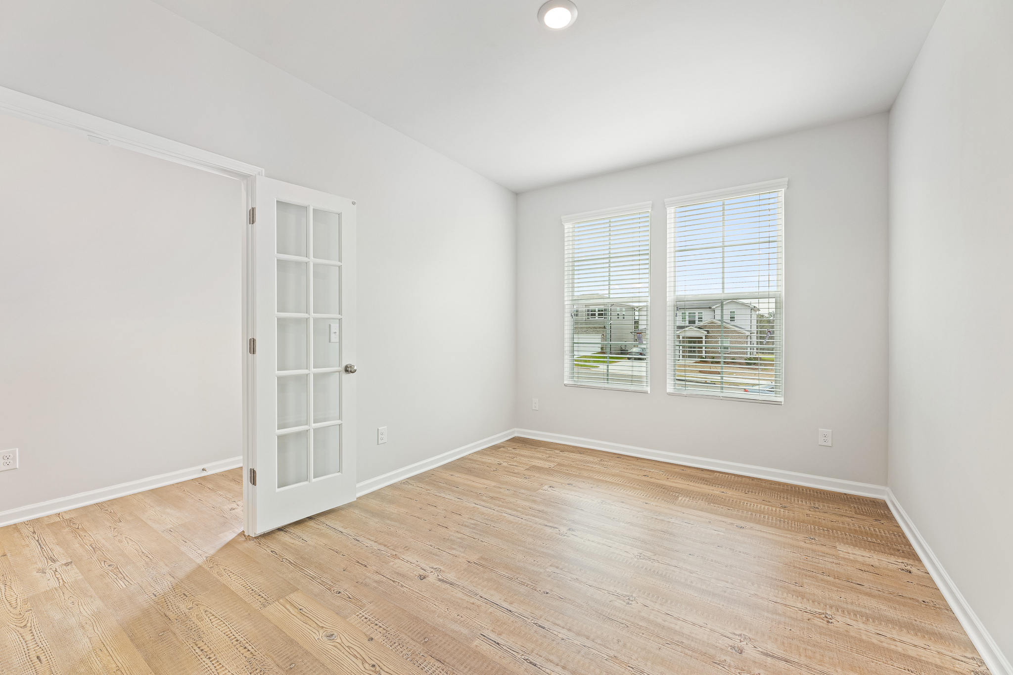 A room with a wood floor and a white door.