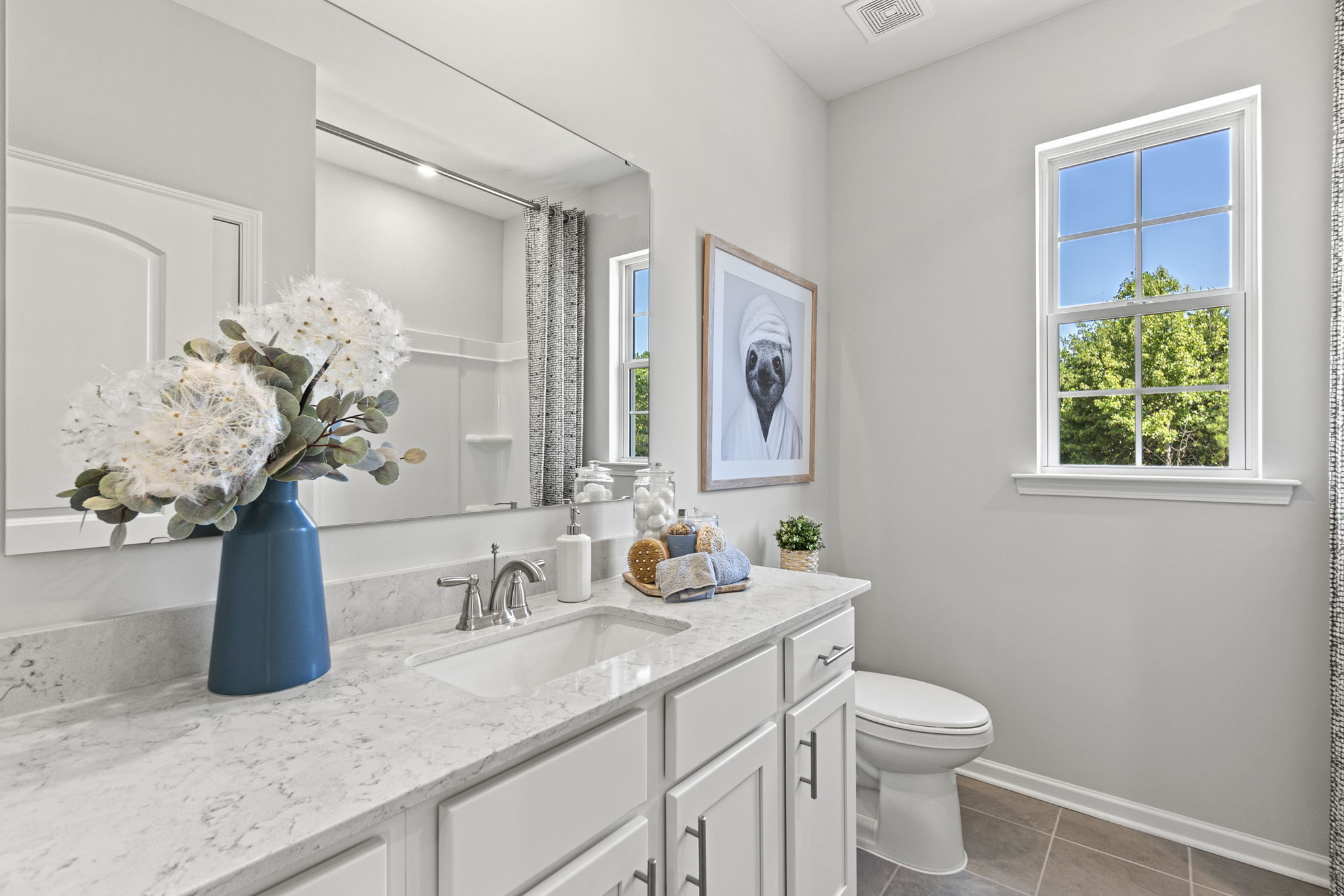 A bathroom with a vase of flowers.