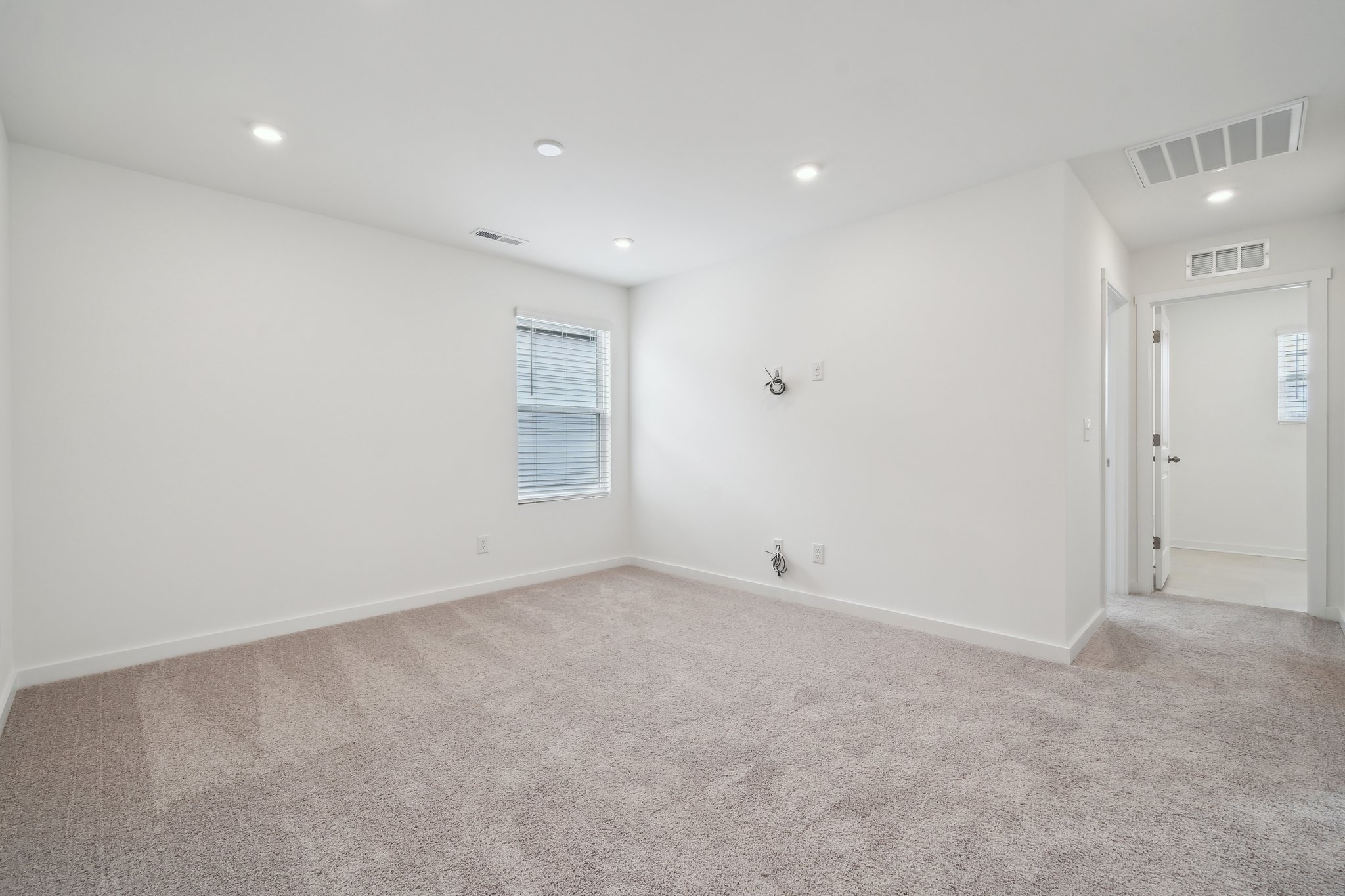 A room with a carpet and a door.