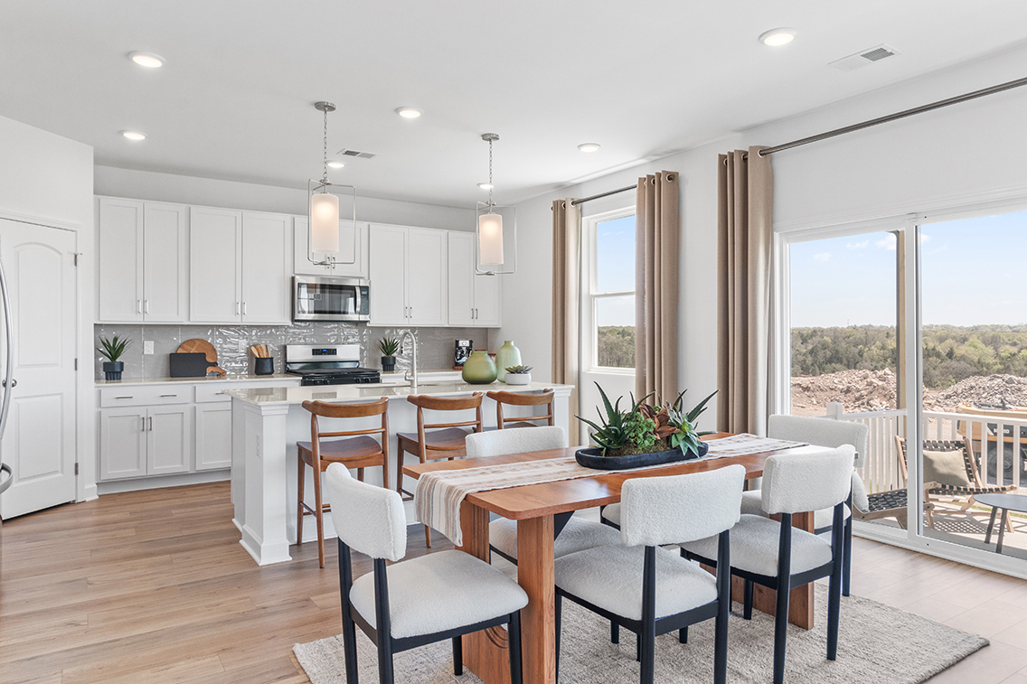 A kitchen with a dining table and chairs.