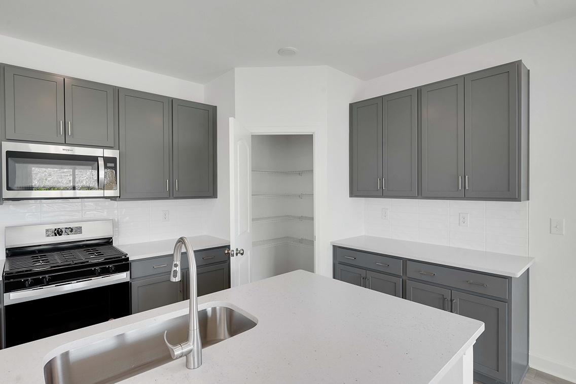 A kitchen with white cabinets.