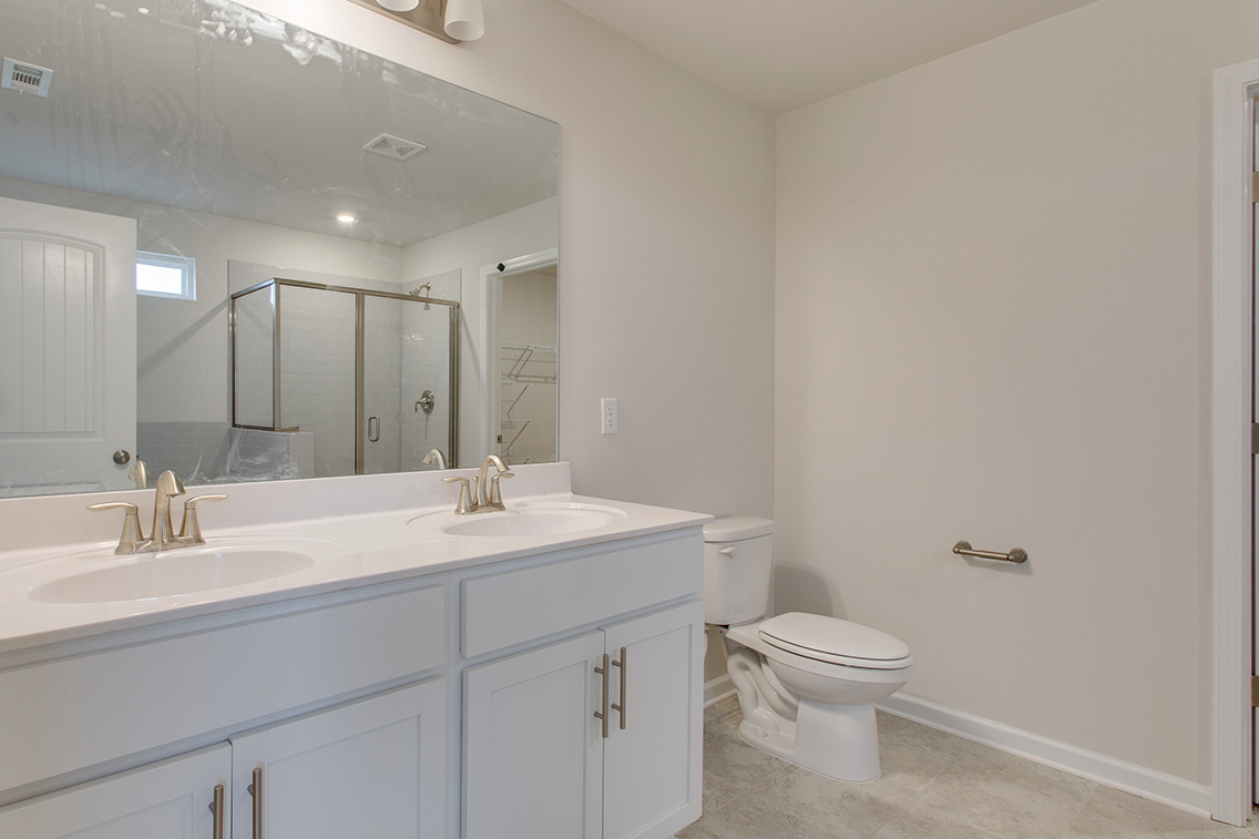A bathroom with a toilet sink and mirror.