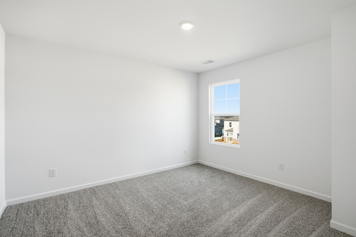 A room with a window and carpet.