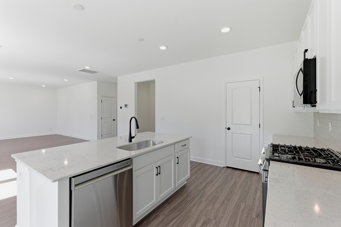 A kitchen with white cabinets.