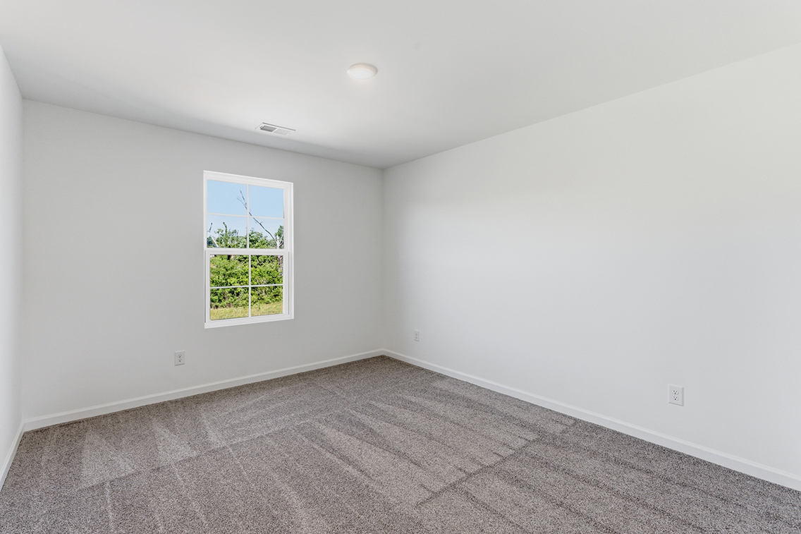 A room with a window and a rug.