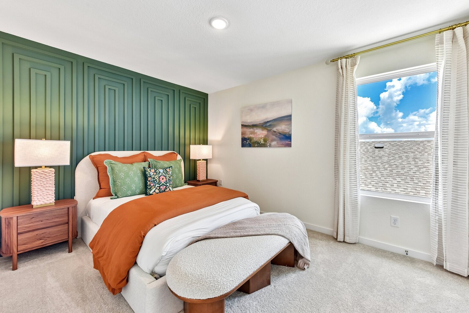 A bedroom with a bed and a bench.