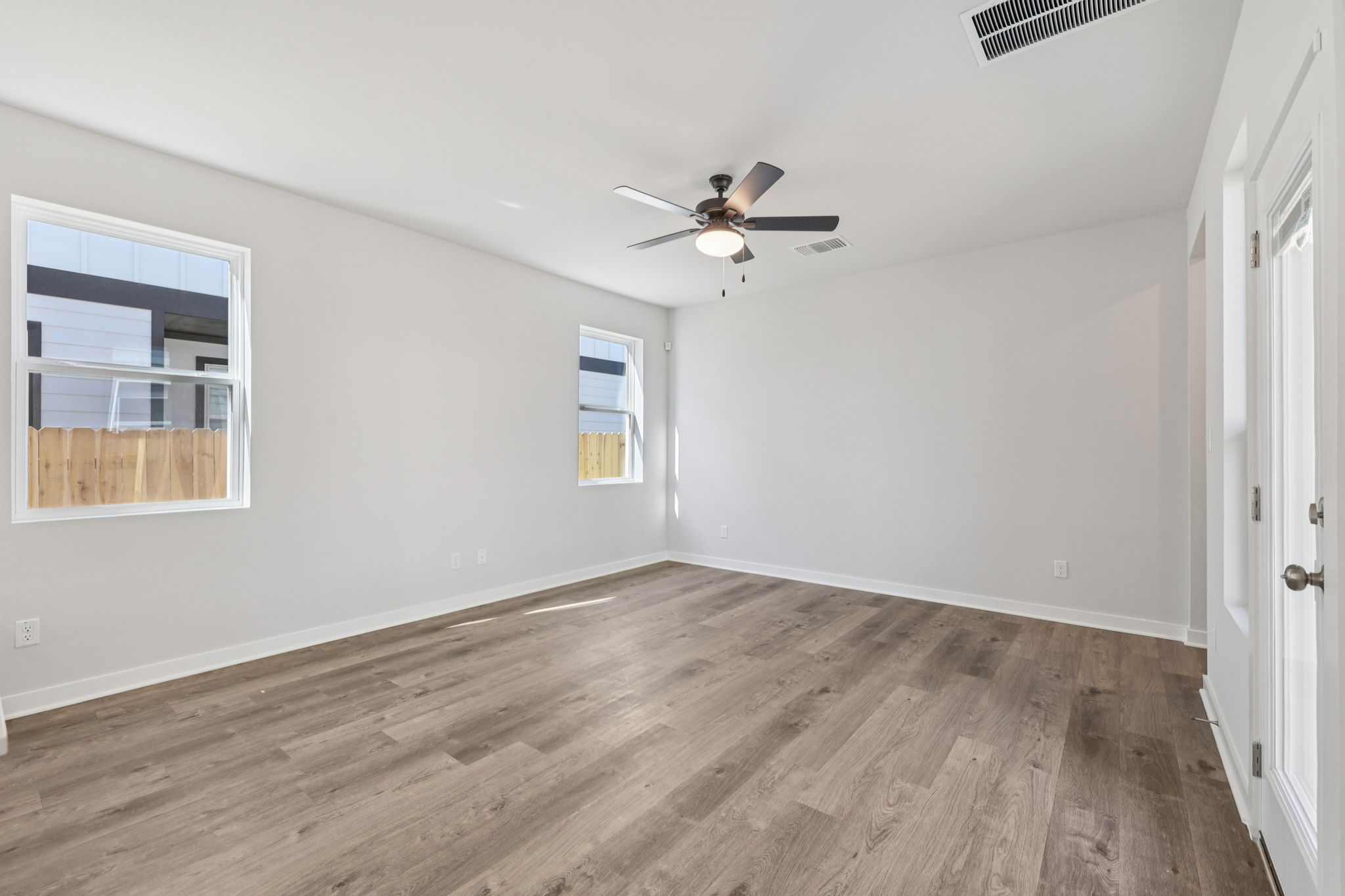A room with a wood floor and a ceiling fan.