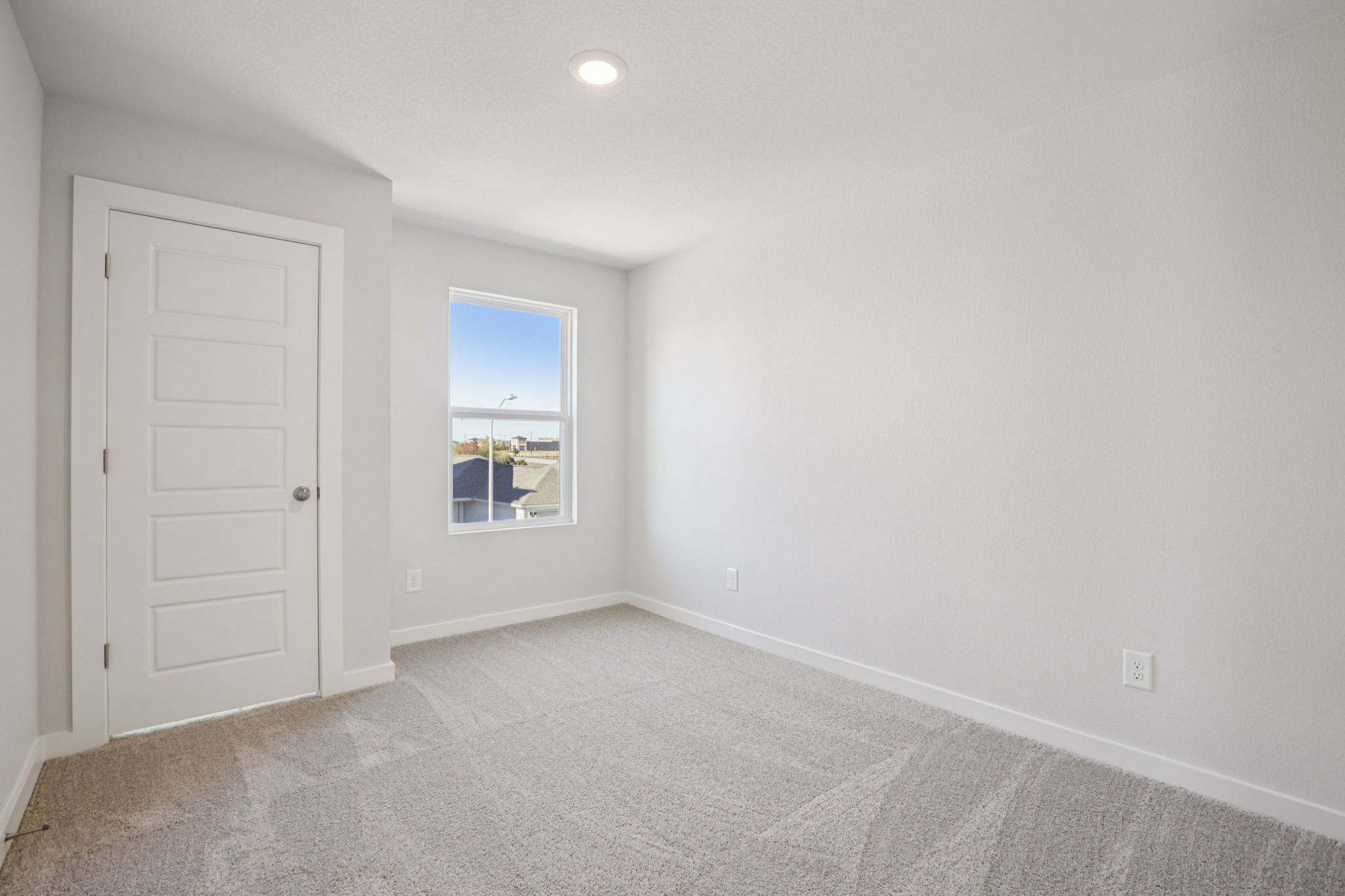 A room with a window and a carpet.