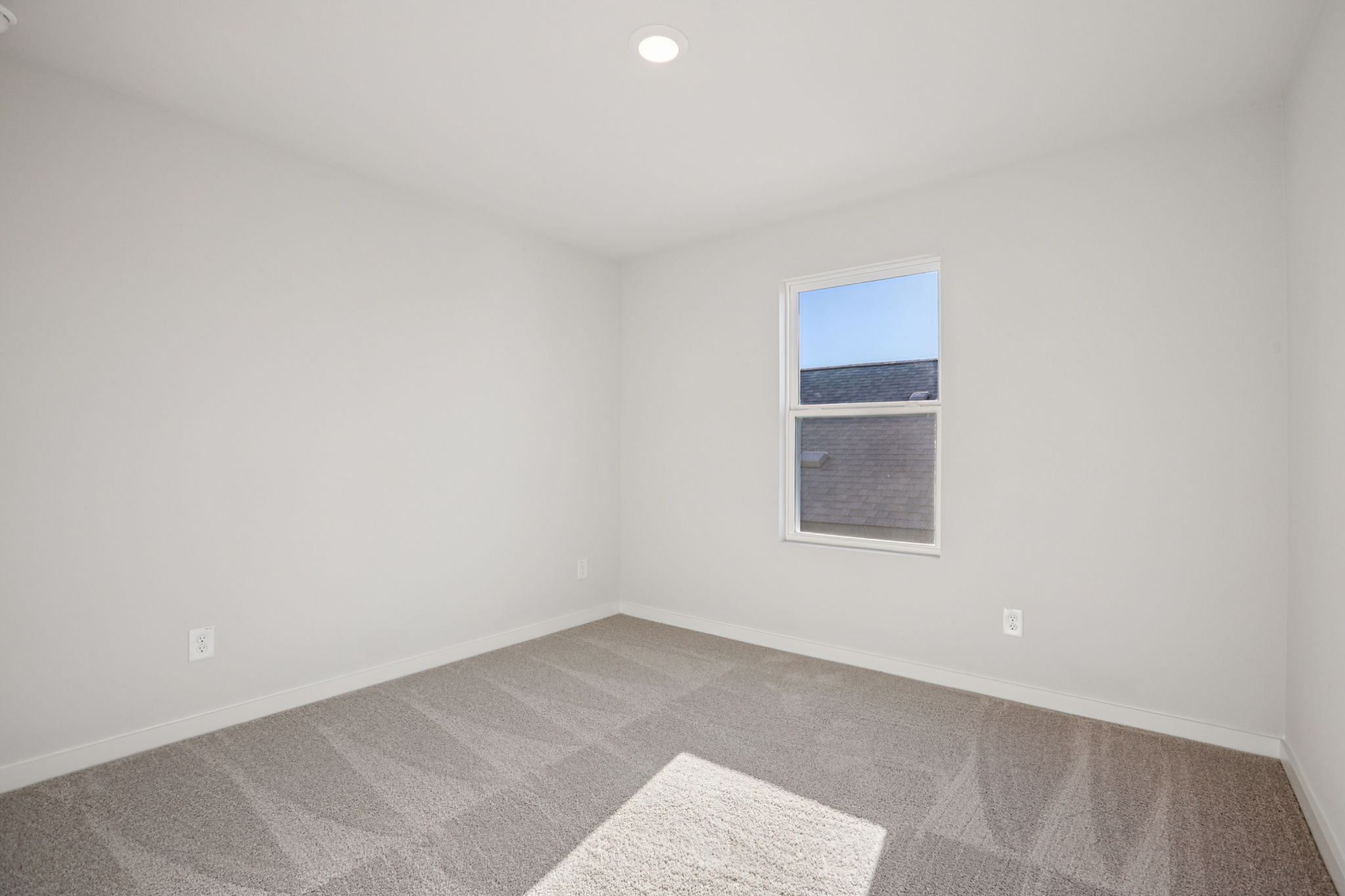 A room with a window and carpet.