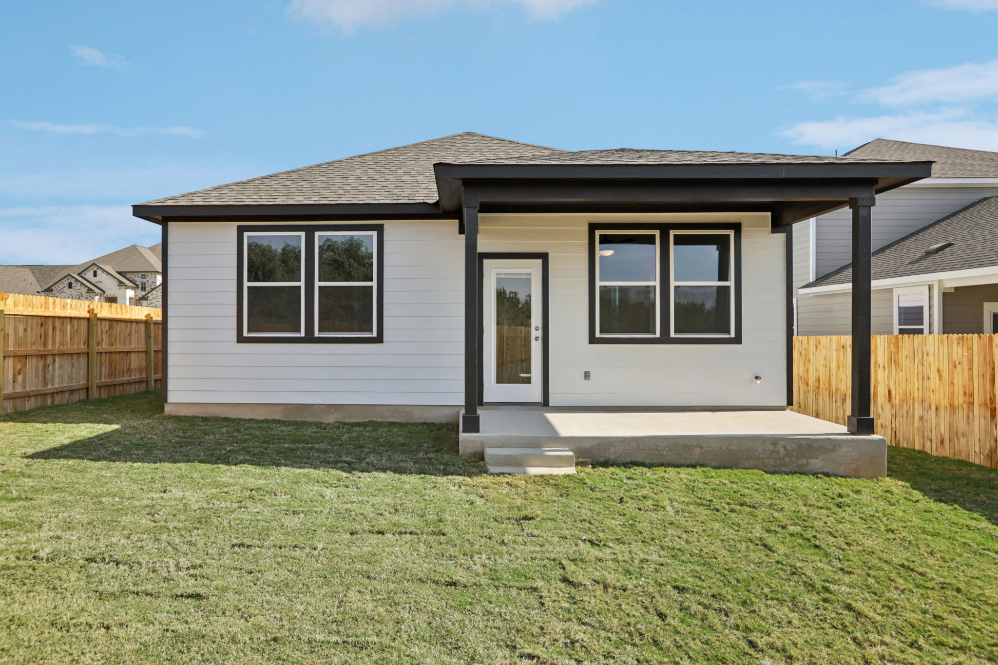 A house with a fence and grass.