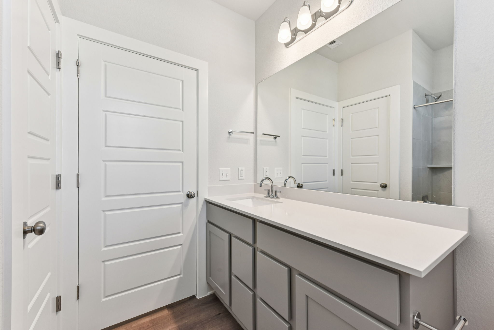 A bathroom with white cabinets.